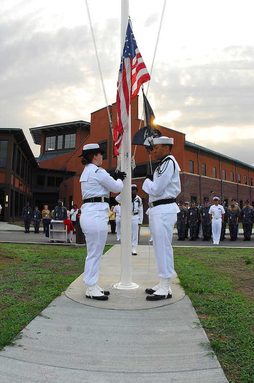 Hospital Corpsman 3rd Class Kailey Wellington (left), from Phoenix, Ariz., hoists the Ensign while HM2 Daniel Nunez, from Chesapeake, Va., manages the halyard during the presentation of morning colors at Naval Health Clinic Charleston on Joint Base Charleston-Weapons Station, May 13. (U.S. Navy photo/Machinist’s Mate 3rd Class Brannon Deugan)