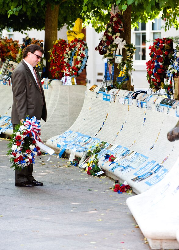 Special Agent Bob Powers, Air Force Office of Special Investigations, reads the engraved names of fallen law enforcement members at the National Law Enforcement Officers Memorial in Washington, D.C. SA Powers and several other OSI members visited the National Law Enforcement Officers Memorial May 16 to place a memorial wreath and to honor all of OSI's fallen heroes. The names of OSI's fallen are chiseled into the memorial along with thousands of other law enforcement professionals who have made the ultimate sacrifice. More than 20,000 friends, family members and colleagues of the fallen are expected to visit the memorial during National Police Week, which runs from May 15-20. (U.S. Air Force Photo by Mike Hastings.)