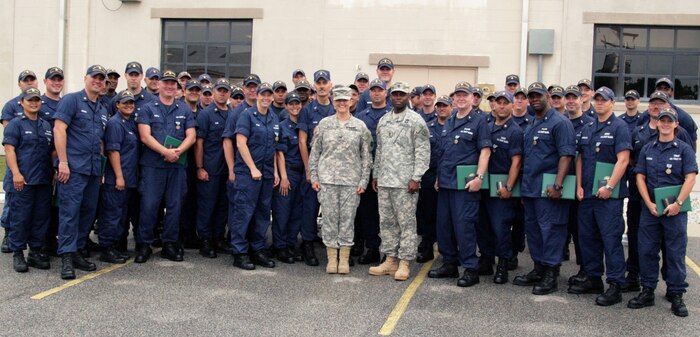Col. Ines White and Sgt. Maj. Kelly Hill visited the U.S. Coast Guard Station Charleston's Military Outload Division May 6, and presented the Army Commendation Medal to nine Coast Guardsmen and the Army Achievement Medal to 56 others. The awards were in recognition of the Coast Guard's security boat crews collaboration with the Army Surface Deployment and Distribution Command, enabling the unit to safely move 3.5 million square feet of military cargo bound for combat operations in the Middle East. Both units, located on Joint Base Charleston - Weapons Station, accomplished this without any operational mishaps or injuries while completing 80 cargo ship evolutions and logging more than 7,200 hours underway for maritime point protection. Colonel White is the 841st Transportation Battalion commander. (U.S. Coast Guard Photo/Chief Boatswain's Mate Stacy Sinke)