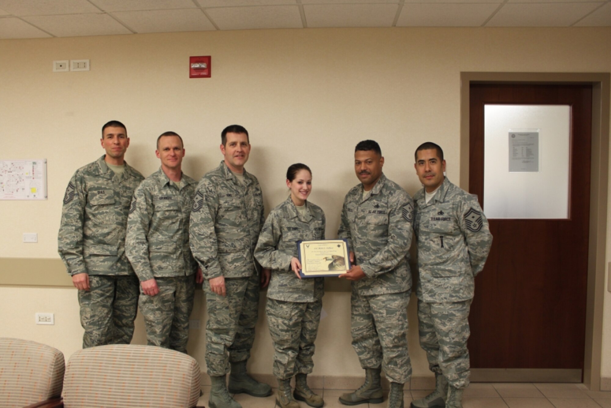 Airman 1st Class Rikki Gilbert, 31st Medical Support Squadron cashier clerk, is presented the Diamond Sharp award for January by the Aviano First Sergeants Council. The Diamond Sharp award is designed to recognize Aviano Airmen who distinguish themselves through outstanding professionalism, impeccable appearance and a "can do" attitude. (Courtesy photo)