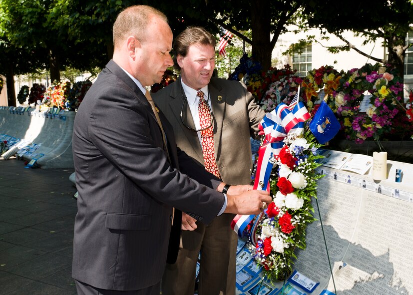 Col. Keith Givens, Air Force Office of Special Investigations vice commander, left, and OSI Special Agent Bob Powers, place a pin shaped like an OSI badge onto a wreath in honor of OSI's fallen heroes. A group from OSI visited the National Law Enforcement Officers Memorial May 16 to place the wreath and to remember all of OSI's fallen heroes. The names of OSI's fallen are chiseled into the memorial along with thousands of other law enforcement professionals who have made the ultimate sacrifice. More than 20,000 friends, family members and colleagues of the fallen are expected to visit the memorial during National Police Week, which runs from May 15-20. (U.S. Air Force Photo by Mike Hastings.)