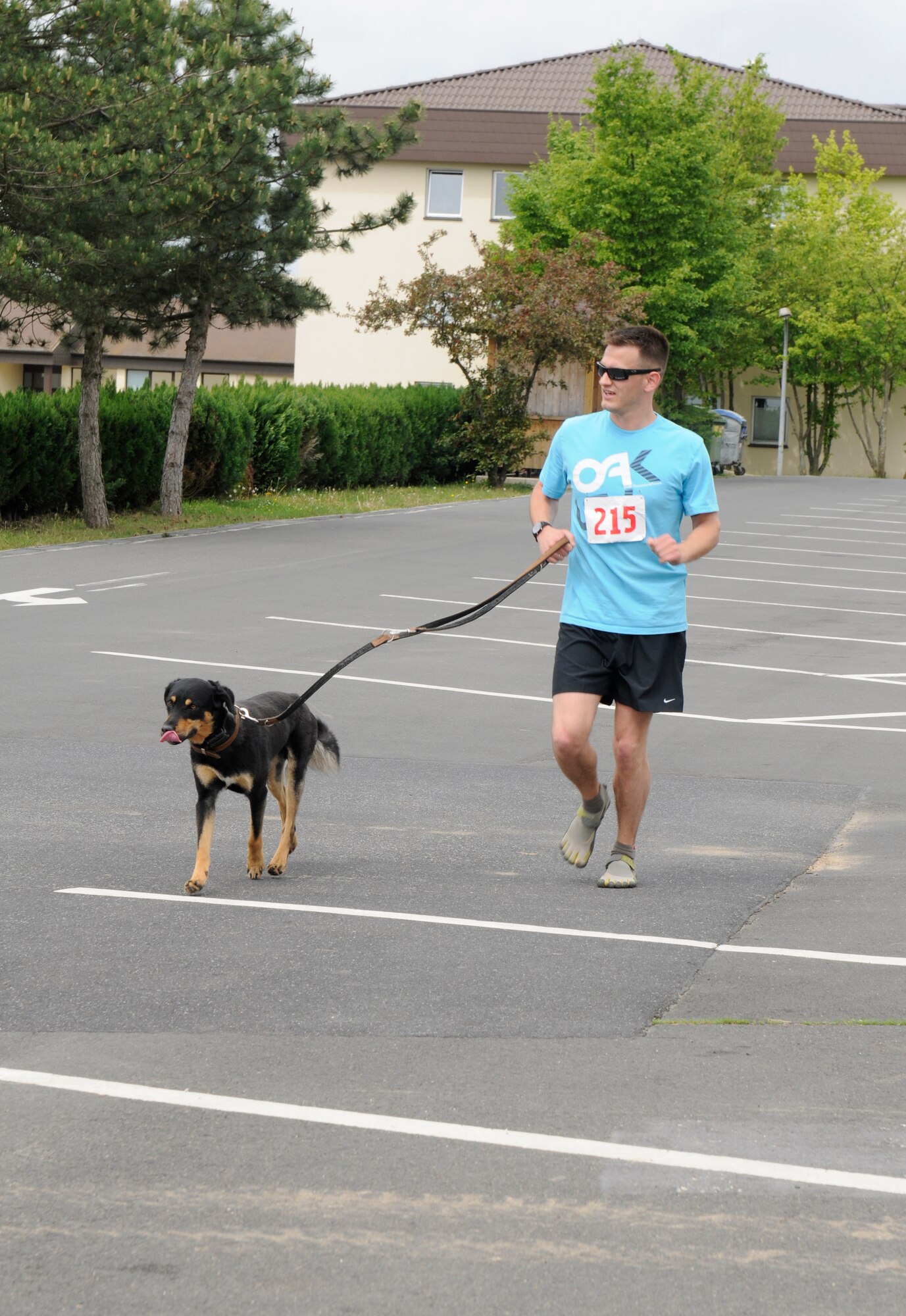SPANGDAHLEM AIR BASE, Germany – Nathanael Callon and his dog, Robby, run to the finish line during the U.S. Air Forces in Europe half marathon at the Skelton Memorial Fitness Center here May 14. The USAFE half marathon is an annual event Airmen from around Europe can participate in. Each run was split into different categories based on age and gender. (U.S. Air Force photo/Airman 1st Class Brittney Frees)