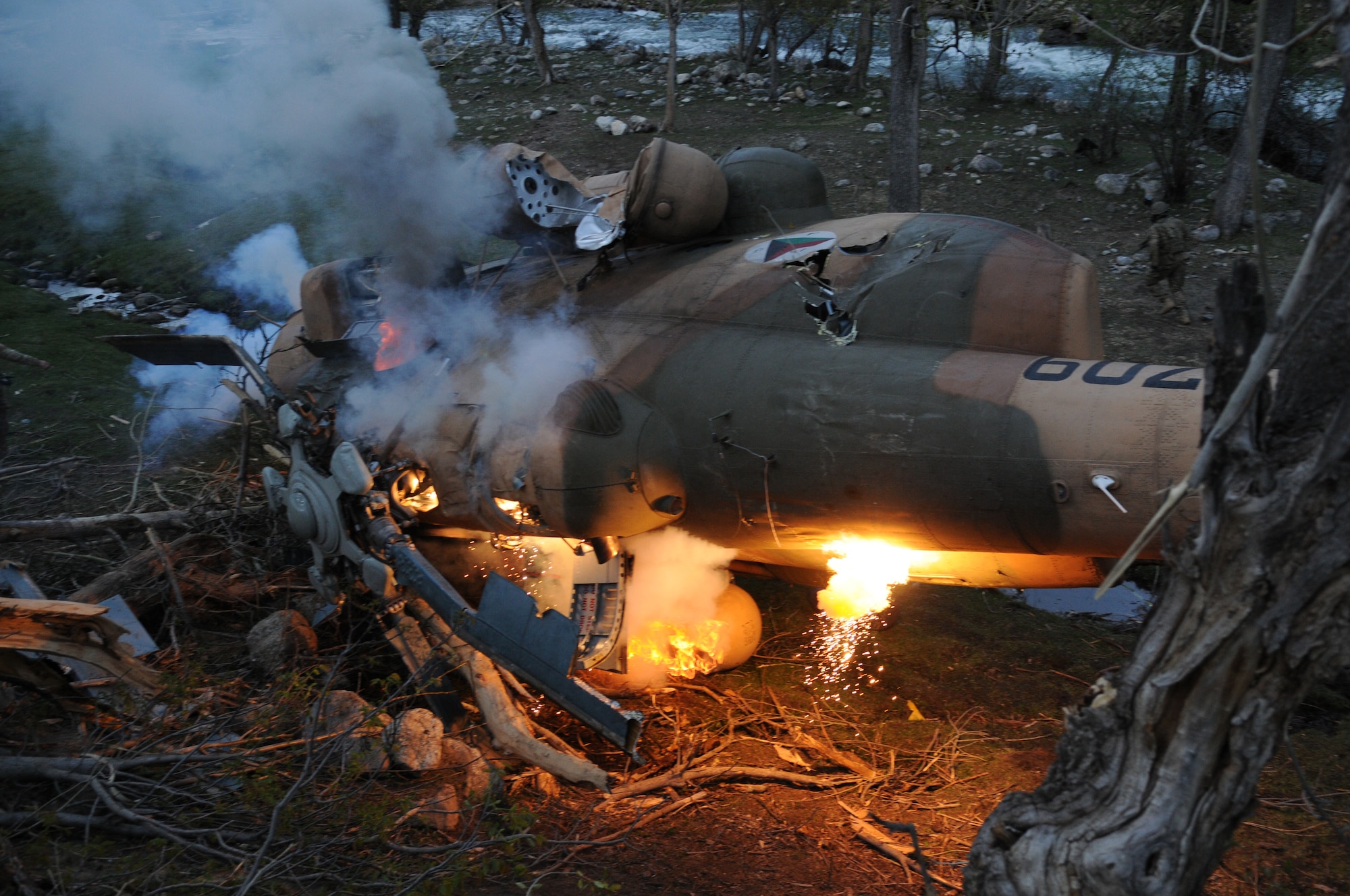 Nuristan,  Afghanistan. Army Pathfinders of Fox Company, 2nd Battalion, 10th Combat Aviation Brigade Fort Drum, NY watch as an Afghan Air Force Mi-17 helicopter burns from phosphorus grenades in the Nuristan province, Afghanistan. The Pathfinders were tasked to provide security around the perimeter and disassemble the crashed aircraft, and remove sensitve items to be sling loaded by a CH-47 Chinook and taken to an airbase. Photo by Tech Sgt. Brian E. Christiansen.