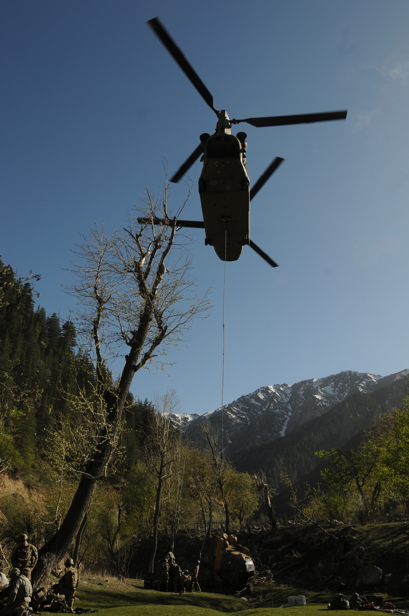 Nuristan,  Afghanistan. Army Pathfinders of Fox Company, 2nd Battalion, 10th Combat Aviation Brigade Fort Drum, NY watch as segments of a Afghan Air Force Mi-17 helicopter is sling loaded away by a CH-47 Chinook. The Pathfinders are tasked to provide security around the perimeter and disassemble the crashed aircraft so it can be sling loaded by a CH-47 Chinook and taken to an airbase. Photo by Tech Sgt. Brian E. Christiansen.