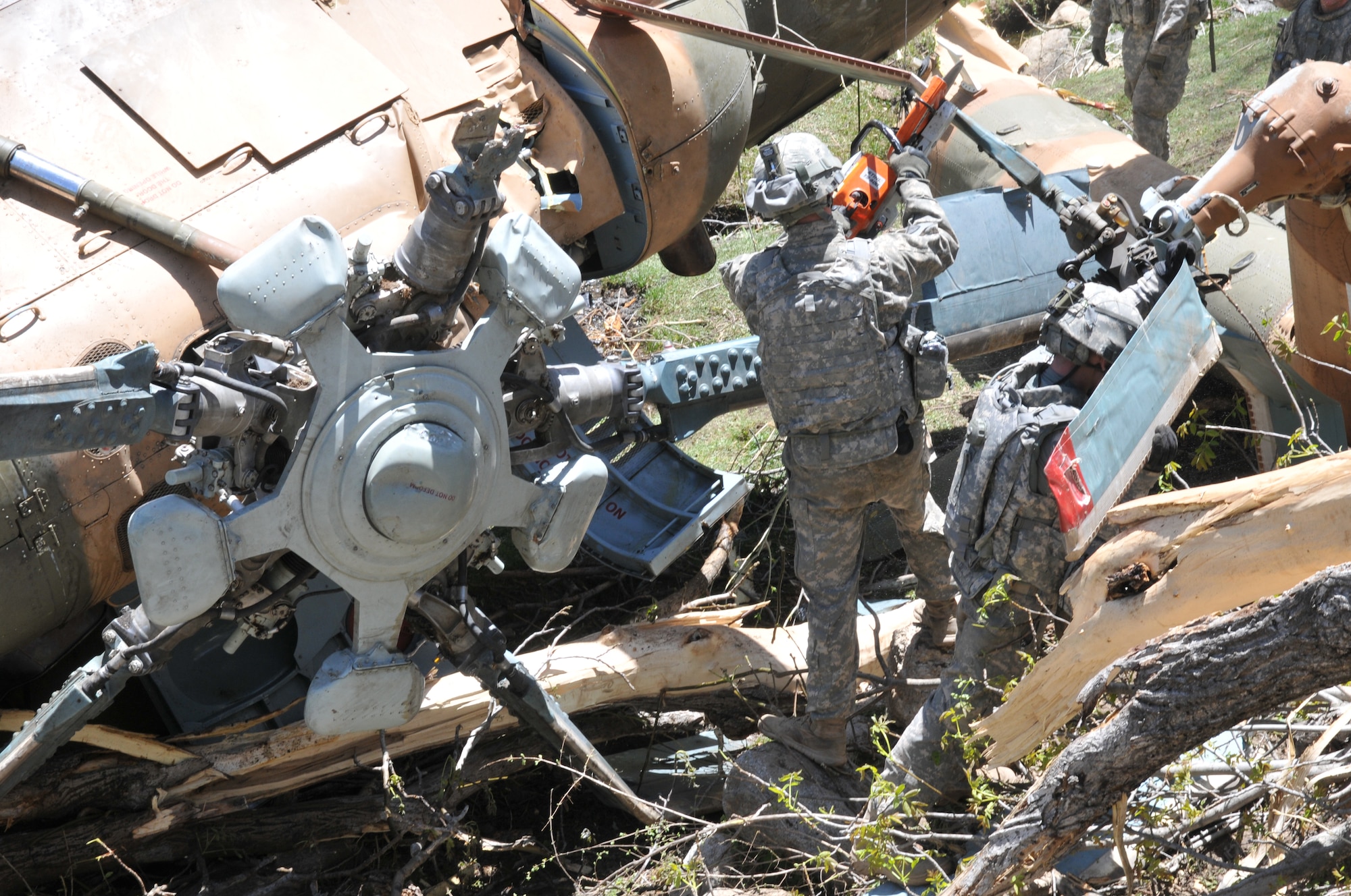 Nuristan,  Afghanistan. Army Pathfinders of Fox Company, 2nd Battalion, 10th Combat Aviation Brigade Fort Drum, NY dissasemble a Afghan Air Force Mi-17 helicopter in the Nuristan province, Afghanistan. The Pathfinders are tasked to provide security around the perimeter and disassemble the crashed aircraft so it can be sling loaded by a CH-47 Chinook and taken to an airbase. Photo by Tech Sgt. Brian E. Christiansen.