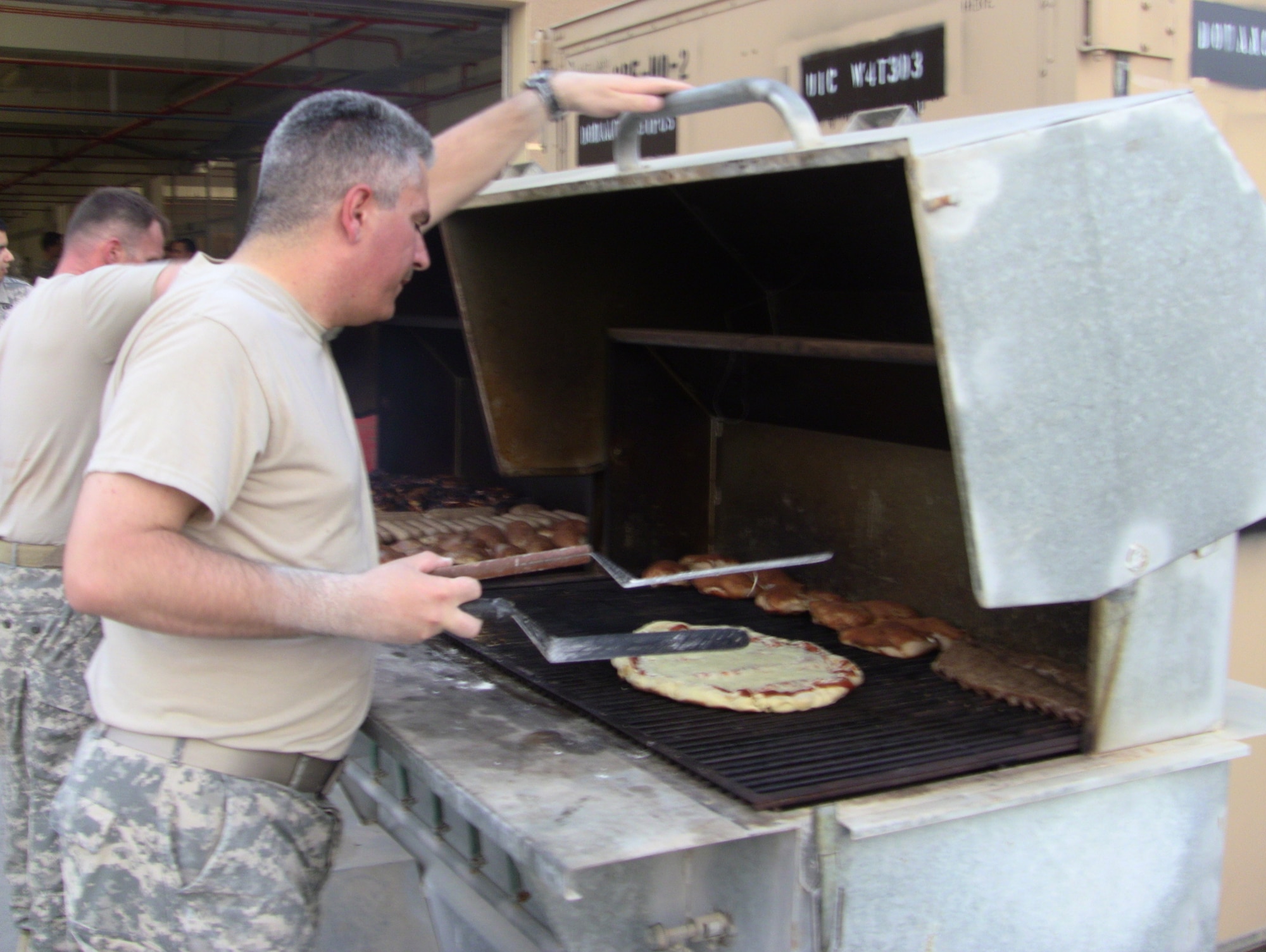 Chief Warrant Officer Jim Chianese attends to his "grill" pizza! (U.S. Air Force photo by Master Sgt. Karl Bradley)