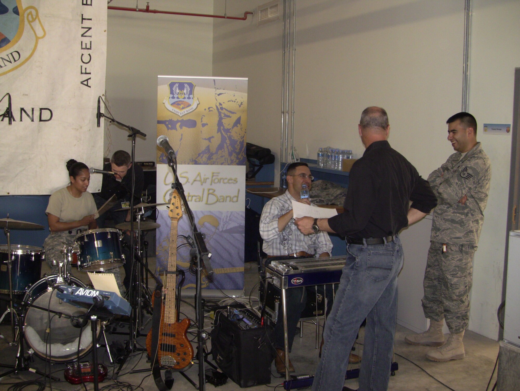 Members of AFCENT Band Wild Blue Country get ready for their special performance while Technical Sgt. Tim Stombaugh gives an impromtu drum-set lesson!