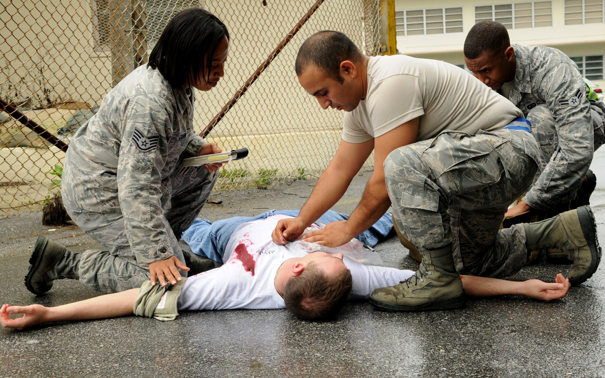 Airmen perform self-aid and buddy care on a “victim” of a scenario involving an active shooter during a local operational readiness exercise, May 17 at Kadena Air Base, Japan. Scenarios like these are common sights during each of Kadena’s LOREs because mimicking real-world situations helps Airmen keep their response skills fresh. (U.S. Air Force photo/ Airman 1st Class Jarvie Z. Wallace)