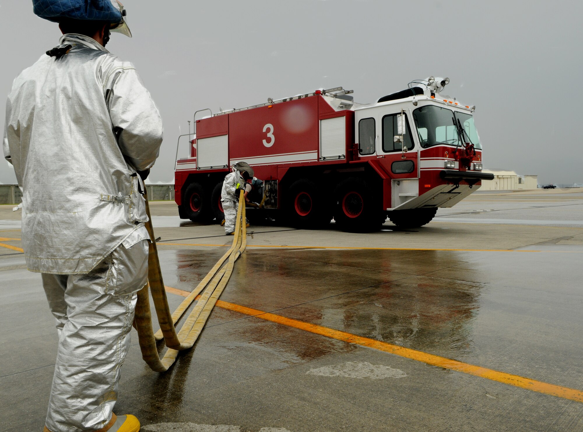 Firemen from the 18th Civil Engineer Squadron turn on a water pump from a fire truck in order to extinguish a simulated fire on an E-3 Sentry aircraft engine at , May 1 at Kadena Air Base, Japan. The simulated engine fire was part of Beverly High 11-04, a local operational readiness exercise, and helped to test the fire department’s ability to respond to an aircraft fire. (U.S. Air Force photo/Airman 1st Class Jarvie Z. Wallace)