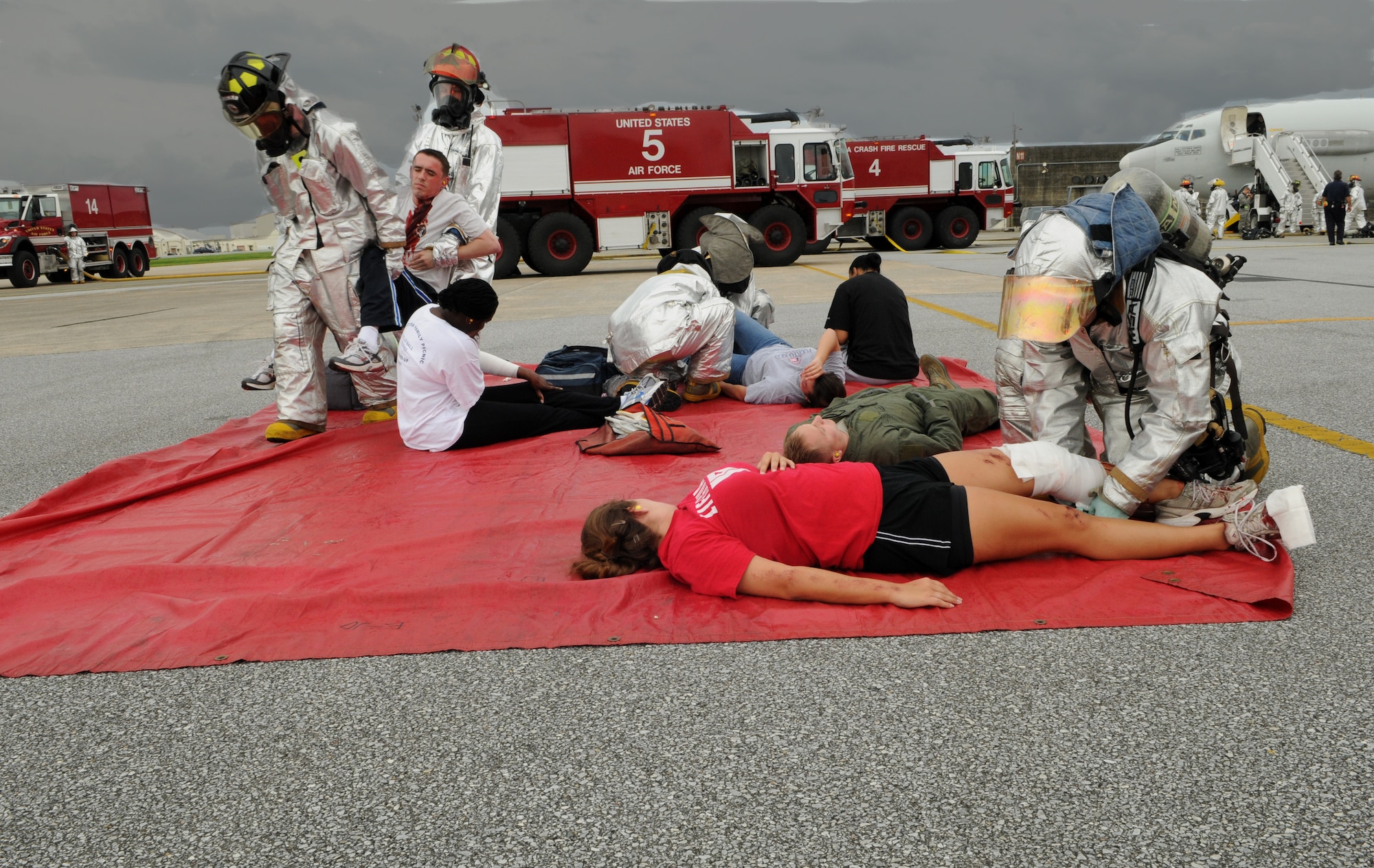 Firemen from the 18th Civil Engineer Squadron, prvovide aid to simulated injured victims who were extracted form a simulated burning of an E-3 sentry aircraft , Japan, May 17 at Kadena Air Base. The simulated engine fire was part of Beverly High 11-04, a local operational readiness exercise, and tested the fire department’s ability to respond to an aircraft fire. (U.S. Air Force photo/Airman 1st Class Jarvie Z. Wallace)