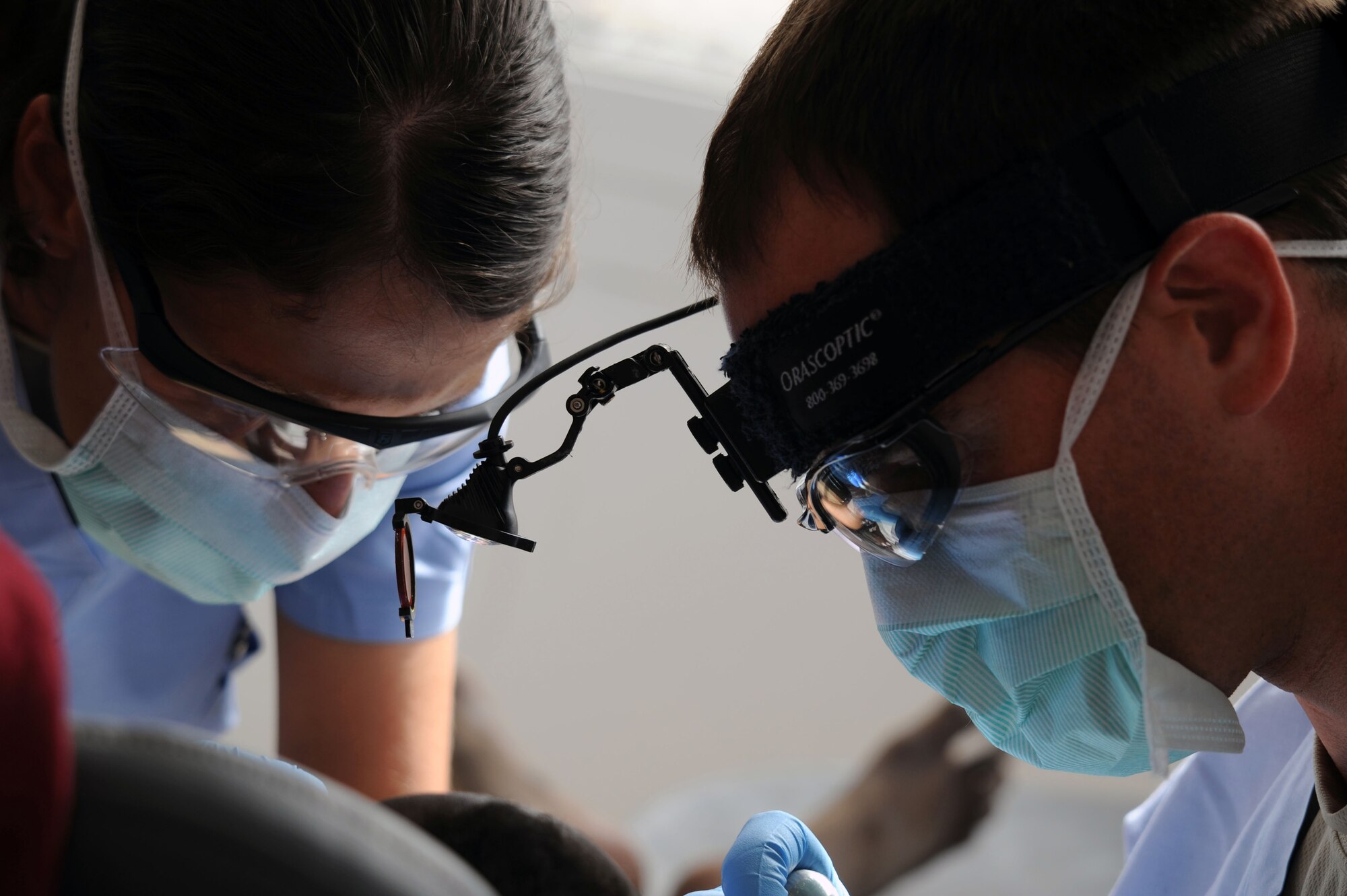 OBOCK, Djibouti - U.S. Air Force Staff Sgt. Leah Potter (left) and U.S. Air Force Capt. Robert Spriggel provide dental treatment for a patient in Obock, Djibouti, during a  Medical Capacity Program (MEDCAP) mission, May 5. Dentists performed wellness checks and treated patients needing care for periodontal diseases and other conditions. The MECAP also hosted optometric and preventative care, and involved Djiboutian Health Ministry personnel, local care providers and 20 soldiers assigned to the 402nd Civil Affairs Battalion which is attached to Combined Joint Task Force - Horn of Africa. (U.S. Air Force photo by Lt. Col. Leslie Pratt)
