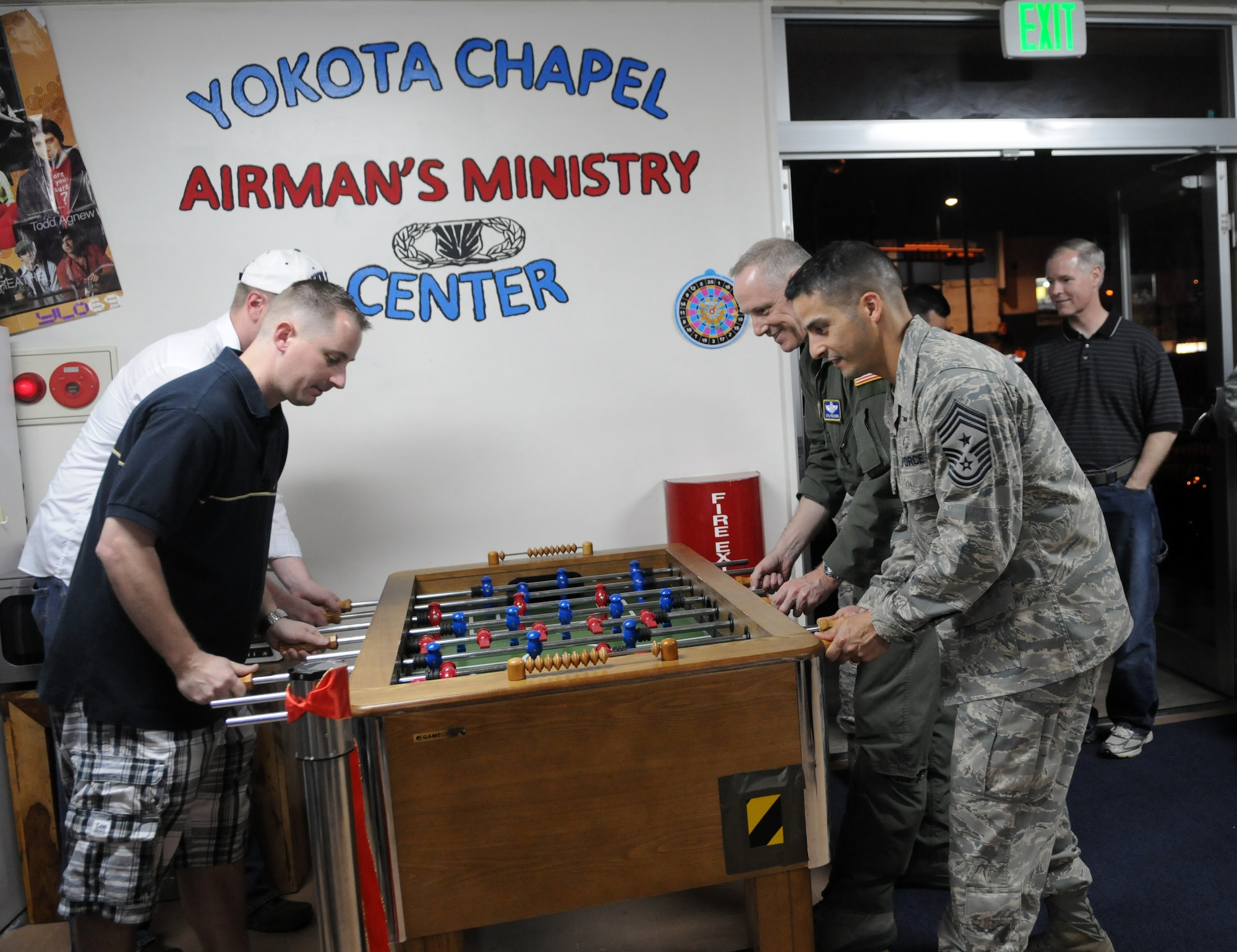 YOKOTA AIR BASE, Japan -- Col. Otto Feather, 374th Airlift Wing commander, and Chief Master Sgt. Ben Caro, 374th Airlift Wing command chief master sergeant, plays foosball with Team Yokota members during the grand opening of the Airman Recreation Center at Yokota Air Base, Japan, May 13, 2011. The center offers recreation activities such as video game systems, foosball tables, and movies. (U.S. Air Force photo/Airman 1st Class Krystal M. Garrett)