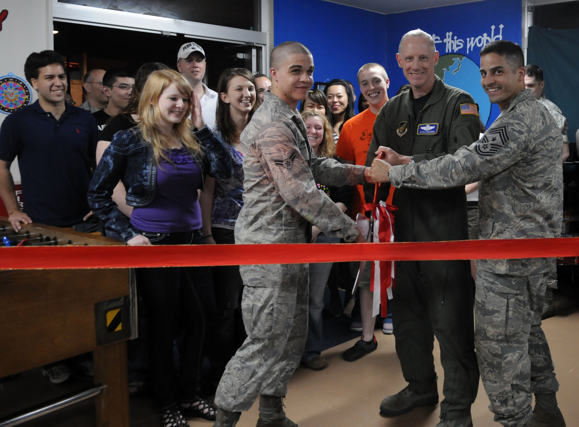 YOKOTA AIR BASE, Japan -- From left to right, Airman 1st Class Korey Pepper, 374th Maintenance Squadron non-destructive inspection journeyman, Col. Otto Feather, 374th Airlift Wing commander, and Chief Master Sgt. Ben Caro, 374th Airlift Wing command chief master sergeant, cut the ribbon for the grand opening of the Airman Recreation Center at Yokota Air Base, Japan, May 13, 2011. The Airman Recreation Center is a place for Team Yokota members, E-1 through E-4 and dependents 18 and older who have graduated high school, to socialize. Yokota's chaplain service funds the Airman Recreation Center in space provided by the 374th AW in building 2085, across the street from the Enlisted Club. (U.S. Air Force photo/Airman 1st Class Krystal M. Garrett)