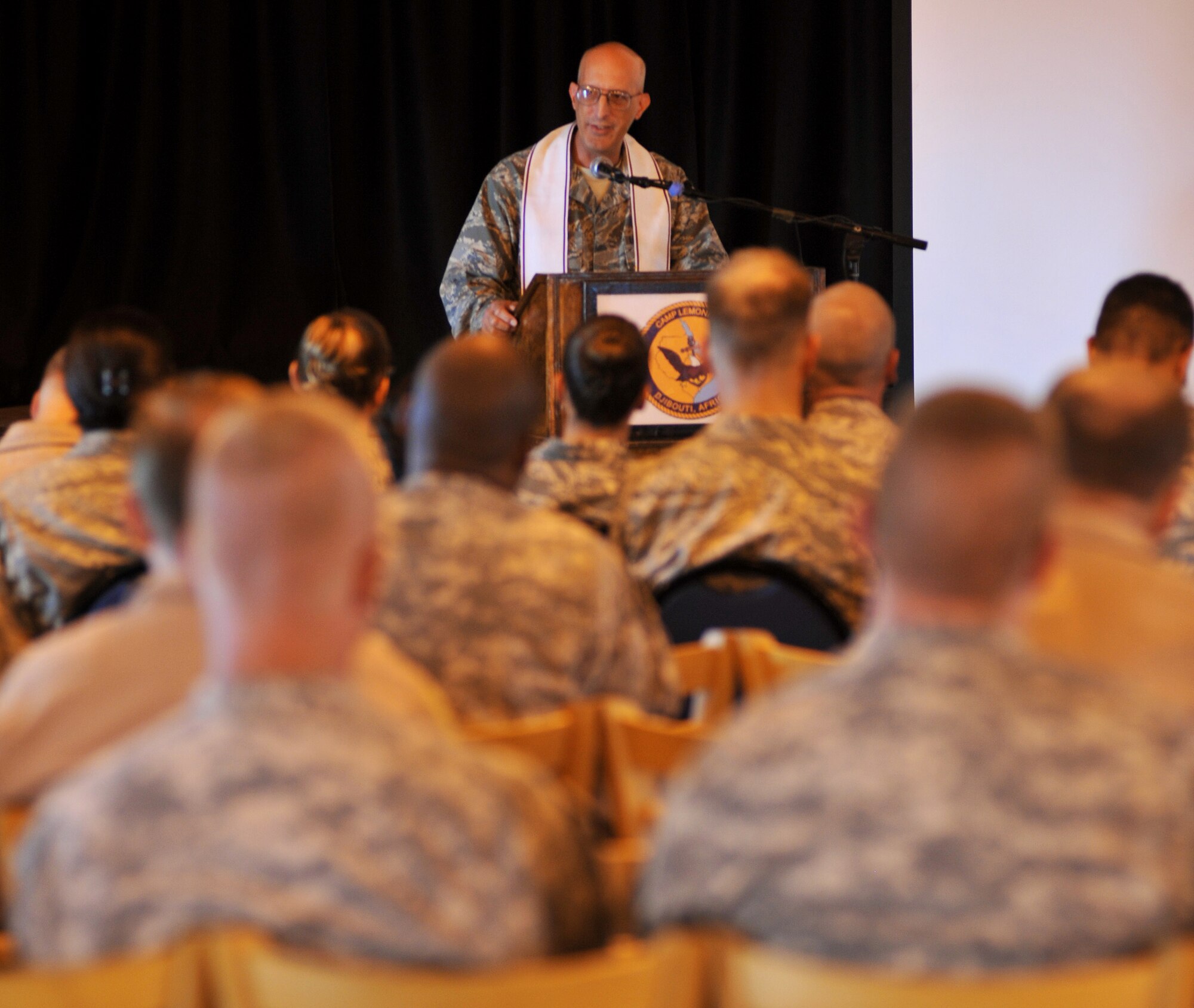 CAMP LEMONNIER, Djibouti – Chaplain (U.S. Air Force Lt. Col.) David Terrinoni, Combined Joint Task Force-Horn of Africa, provides a scripture reading during a memorial service May 10 at the 11 Degrees North community center. The service was held to honor the eight airmen and one civilian killed at an Afghanistan airport April 27. (U.S. Air Force photo by Staff Sgt. R.J. Biermann)