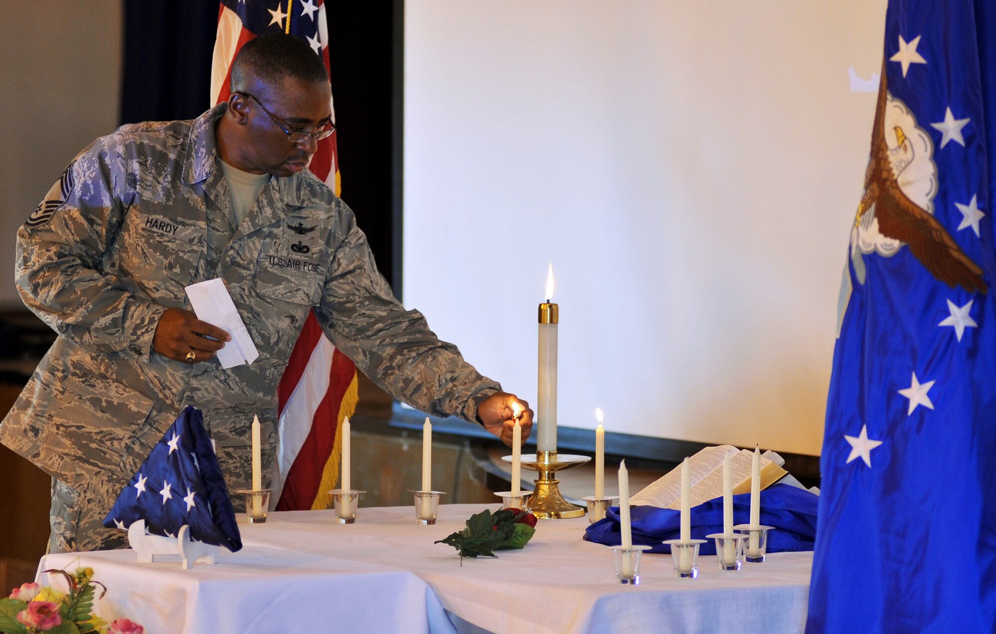 CAMP LEMONNIER, Djibouti – U.S. Air Force Chief Master Sgt. James Hardy, 449th Air Expeditionary Group senior enlisted leader, lights a candle to honor the memory of U.S. Air Force Maj. Philip Ambard, Buckley Air Force Base, Colo., during a memorial service May 10 at the 11 Degrees North community Center. Ambard was one of nine people killed April 27 at an Afghanistan airport. (U.S. Air Force photo by Staff Sgt. R.J. Biermann)