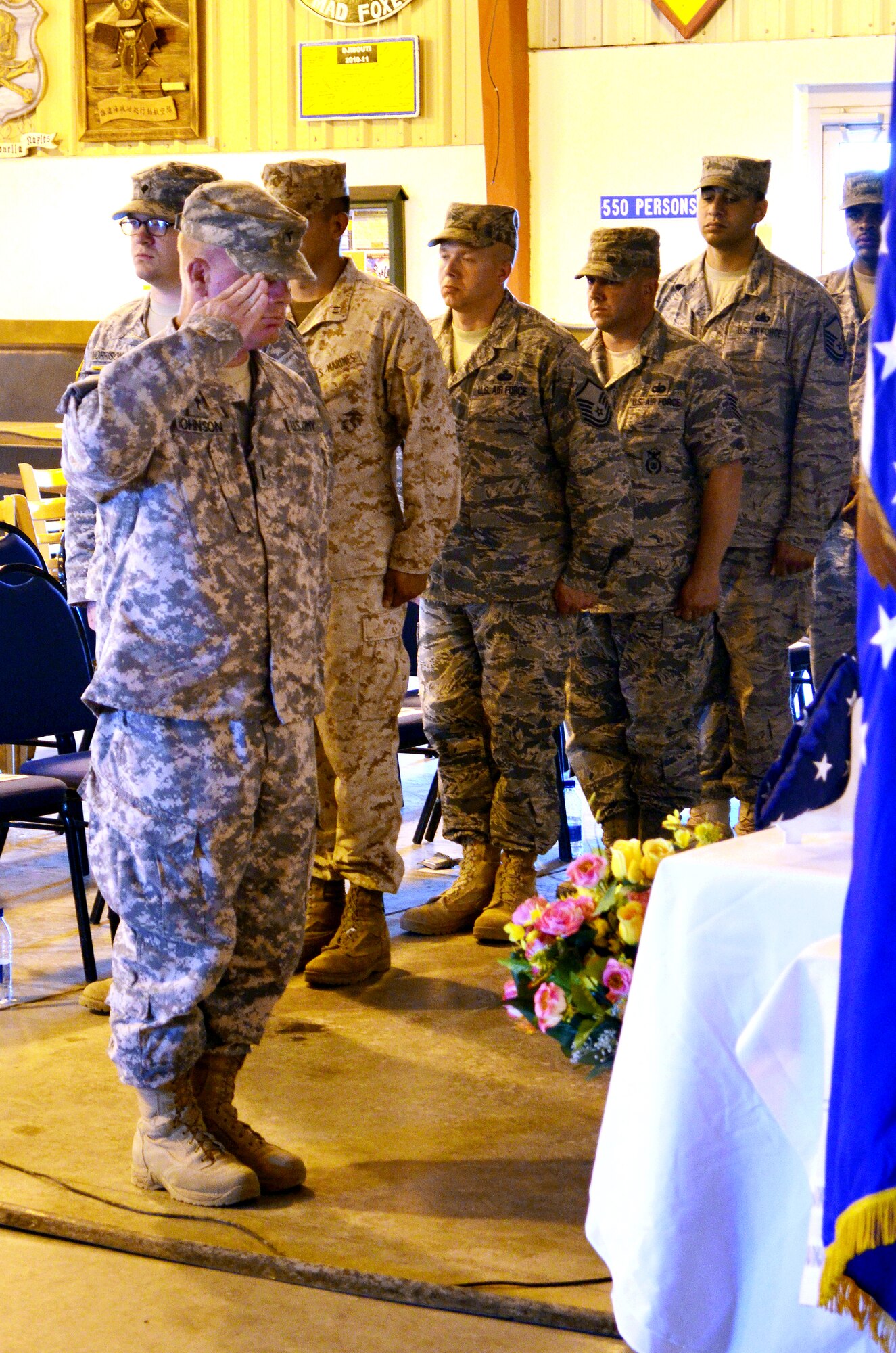 CAMP LEMONNIER, Djibouti – U.S. Army 1st Lt. Monty Johnson salutes the U.S. Flag at the memorial service held May 10 at the 11 Degrees North community center. The memorial service was held to honor nine people who were recently killed during an attack at an Afghanistan airport on April 27. More than 70 Combined Joint Task Force - Horn of Africa servicemembers attended the service. (Photo by U.S. Army Specialist Michelle C. Lawrence)