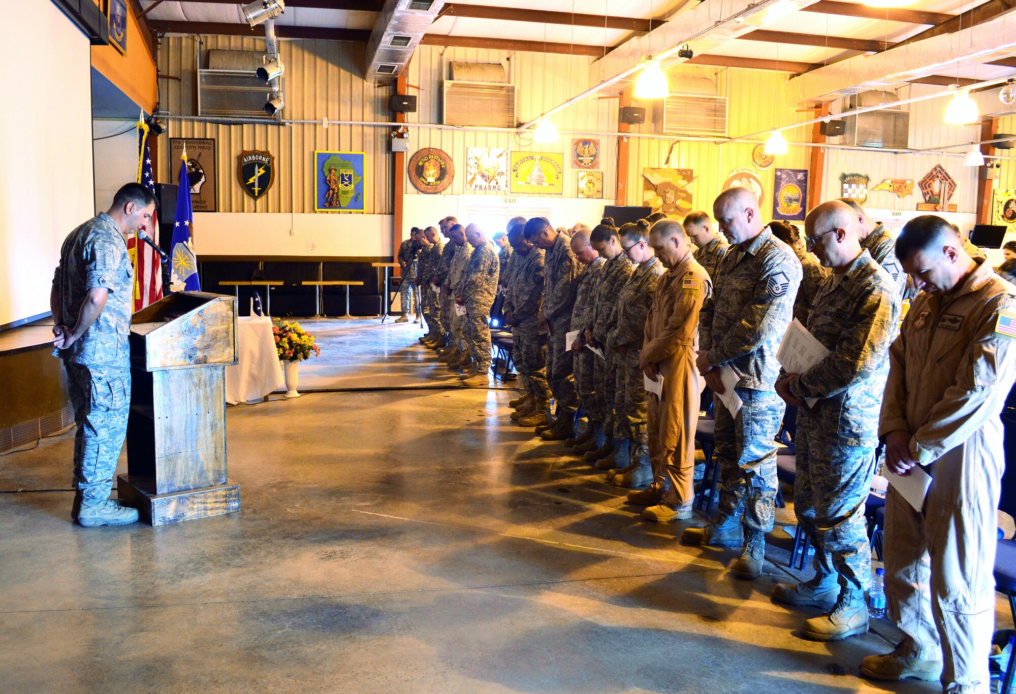 CAMP LEMONNIER, Djibouti -- U.S. Air Force Col. Michael Morelock, 449th Air Expeditionary Group commander (far right), pauses during the opening prayer at a memorial service May 10 at the 11 Degrees North community center. The service was held to honor nine people killed during an attack at an Afghanistan airport April 27. (U.S. Army photo by Specialist Michelle C. Lawrence)