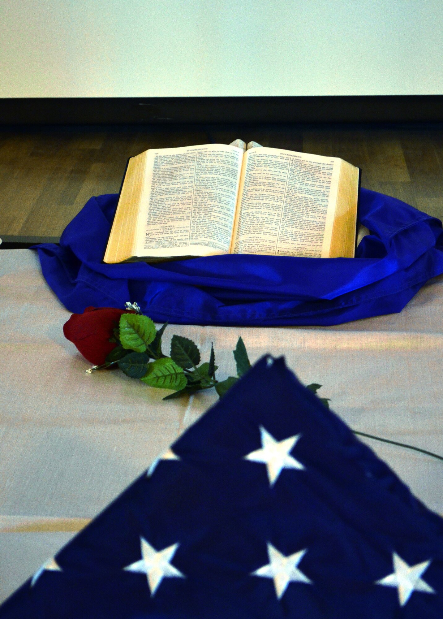 CAMP LEMMONIER, Djibouti -- A table at the 11 Degrees North community center containing the U.S. Flag, a rose and the Bible was set-up as part of a memorial service held May 10 to honor nine people killed in an attack at an Afghanistan airport April 27. The ceremony ended with more than 70 Combined Joint Task Force - Horn of Africa servicemembers who attended the service walking up to the table and saluting the U.S. Flag.(Photo by U.S. Army Specialist Michelle C. Lawrence)