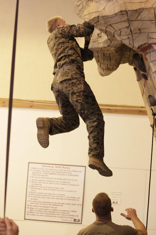 Lance Cpl. Lyle Anderson, a student of the Assault Climbers Rehearsal Course, hangs from a cliff while he learns bouldering during the course May 18, 2011 in the Mountain Warfare Training Center Gym.