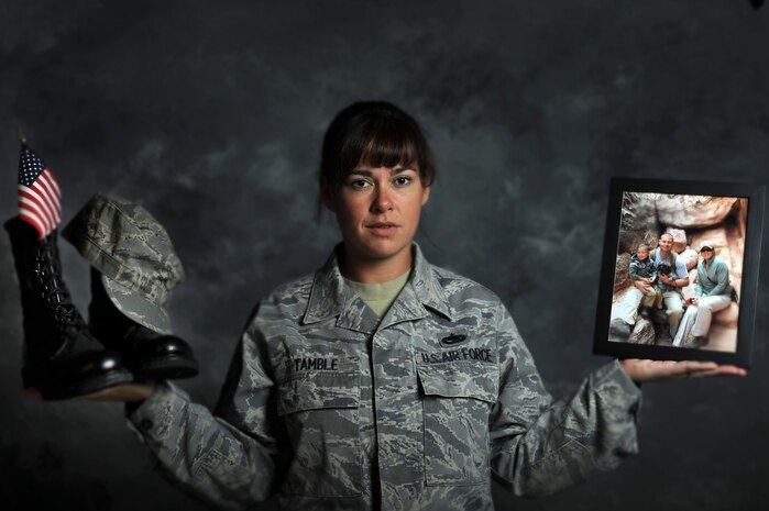 NELLIS AIR FORCE BASE, Nev. --  Tech. Sgt. Jennifer Tamble a munitions systems craftsman from the 57th Maintenance Squadron demonstrates the delicate balance needed to have  a military career and a family. Tech. Sgt. Tamble has served on active duty for 11-years and is responsible for munitions storage, maintenance, inspection and buildup. She is also the mother of 3-year-old Henry, and the wife of Tech. Sgt. Christopher Tamble.  (U.S. Air Force illustrative photo by Staff Sgt. Taylor Worley)