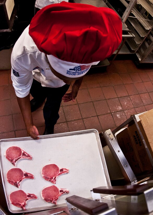 Tech. Sgt. Jason Williams, 919th Force Support Squadron, slides more pork chops into the oven during the May unit training assembly at Duke Field.  Recently, the 919th FSS dining facility picked up its sixth John L. Hennessy award since 2000.  (U.S. Air Force photo/Tech. Sgt. Samuel King Jr.)
