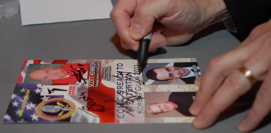 KUNSAN AIR BASE, Republic of Korea -- Comedians Tony Deyo, Mike Pace and Scott Kennedy sign autographs for Wolf Pack Airmen May 18 at the Loring Club here. Armed Forces Entertainment hosts more than 1,200 shows each year, reaching in excess of 500,000 personnel at 270 military installations worldwide. From make-shift stages to show-stopping extravaganzas, the performances bring a piece of home to those stationed far away from home. (U.S. Air Force photo/Master Sgt. Sonny Cohrs)