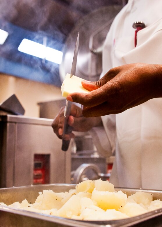 Senior Airman Pamula Roberts, 919th Force Support Squadron, slices off butter onto the potatoes for the main lunch line during the May unit training assembly at Duke Field.  Recently, the 919th FSS dining facility picked up its sixth John L. Hennessy award since 2000.  (U.S. Air Force photo/Tech. Sgt. Samuel King Jr.)