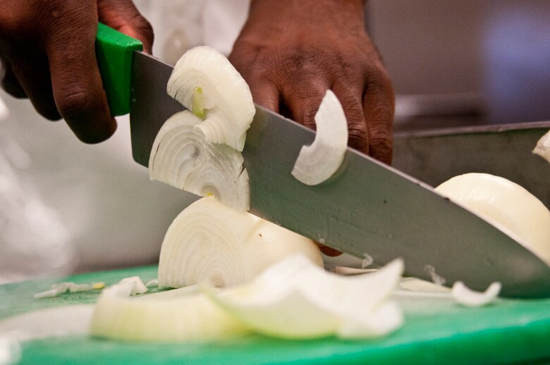 Onions are sliced and dices for the liver and onions lunchtime main course during the May unit training assembly at Duke Field.  Recently, the 919th FSS dining facility picked up its sixth John L. Hennessy award since 2000.  (U.S. Air Force photo/Tech. Sgt. Samuel King Jr.)