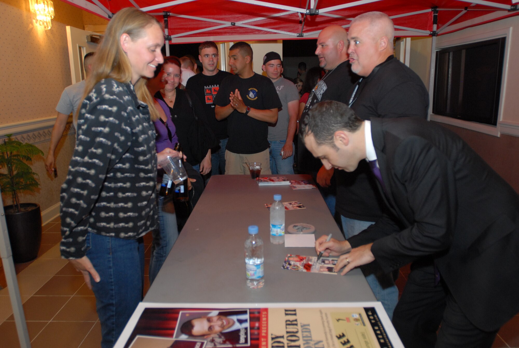 KUNSAN AIR BASE, Republic of Korea -- Staff Sgt. Jeannie Hartman, 8th Comptroller Squadron financial services supervisor, waits for her autograph from Comedian Tony Deyo following an Armed Forces Entertainment comedy show here May 18. Mr. Deyo was joined on stage by Mike Pace and Scott Kennedy as part of AFE’s 2011 tour. (U.S. Air Force photo/Master Sgt. Sonny Cohrs)