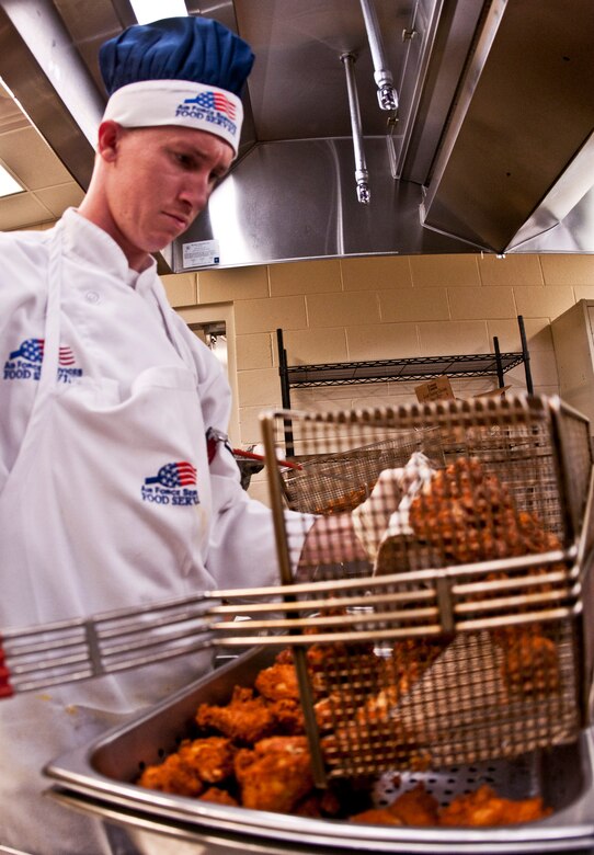 Senior Airman Michael White, 919th Force Support Squadron, pours out freshly fried chicken wings for the lunch time meal during the May unit training assembly at Duke Field y.  Recently, the 919th FSS dining facility picked up its sixth John L. Hennessy award since 2000.  (U.S. Air Force photo/Tech. Sgt. Samuel King Jr.)