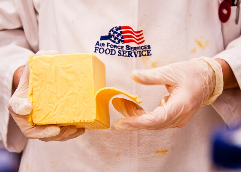 A 919th Force Support Squadron Airman peels strips of cheese for the snack line burgers during the May unit training assembly at Duke Field.  Recently, the 919th FSS dining facility picked up its sixth John L. Hennessy award since 2000.  (U.S. Air Force photo/Tech. Sgt. Samuel King Jr.)