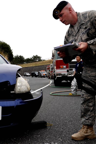 MISAWA AIR BASE, Japan -- Tech. Sgt. Robert Starkweather, 35th Security Forces Squadron senior patrolman, assesses vehicle damage from an accident that occurred in concrete canyon May 11.  According to the 35th Fighter Wing Safety Office, there have been a total of four accidents in concrete canyon in the past three years.  (U.S. Air Force photo/Staff Sgt. April Quintanilla)