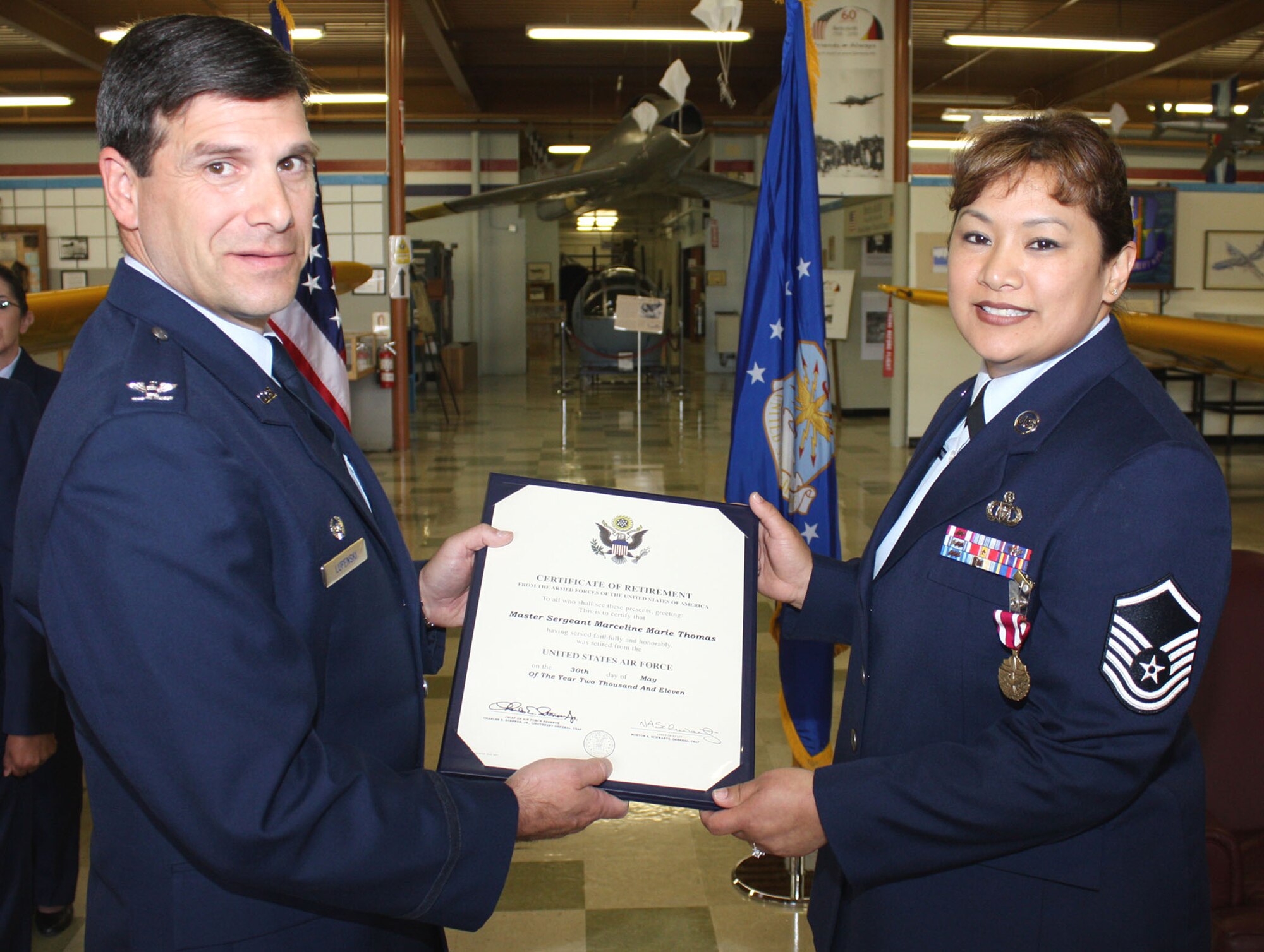 TRAVIS AIR FORCE BASE, Calif. -- Col. Albert Lupenski, 349th Operations Group commander, presents Master Sgt. Marceline Thomas her meritorious service medal certificate during her retirement ceremony at the Travis museum, May 14. (U.S. Air Force photo/Master Sgt. Robert Wade)