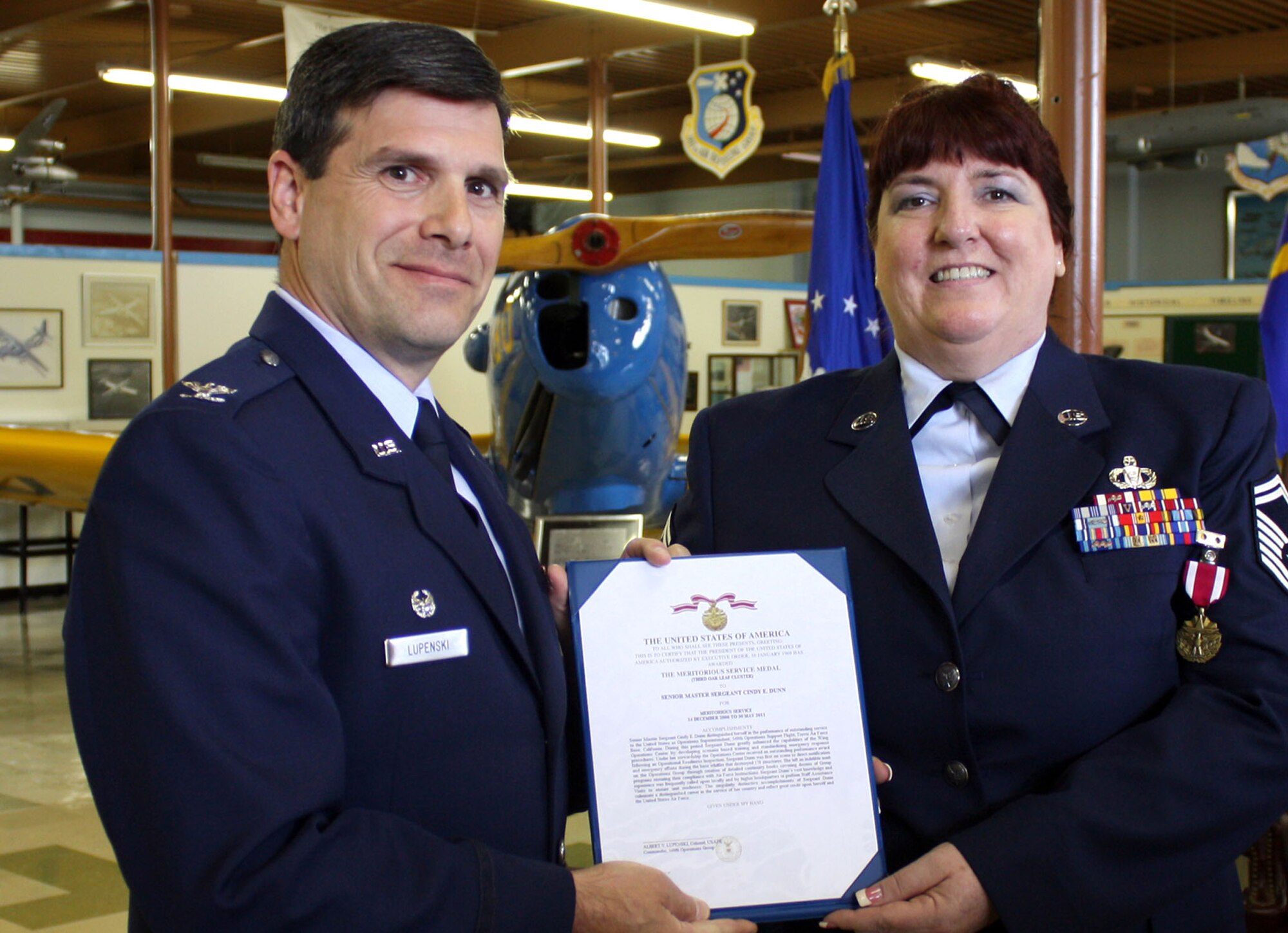TRAVIS AIR FORCE BASE, Calif. -- Senior Master Sgt. Cindy Dunn, 301st Airlift Squadron, receives her meritorious service medal certificate during her retirement ceremony at the Travis museum, May 14. (U.S. Air Force photo/Master Sgt. Robert Wade) 
