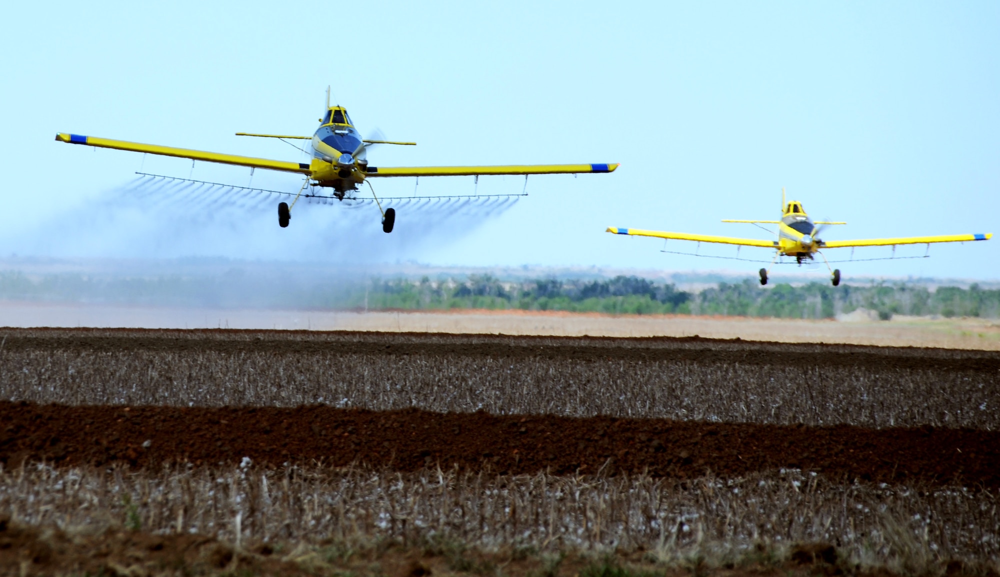 ALTUS AIR FORCE BASE, Okla. -- Two Air Tractor Model 502 aircraft fly eight to 10 feet off the ground to spray local fields May 13. These spray planes will be seen more frequently in the local area starting at the end of May. Spectators are cautioned to keep their distance and remain upwind of the spray. (U.S. Air Force photo/ Airman 1st Class Kenneth W. Norman/ 97th Air Mobility Wing Public Affairs)