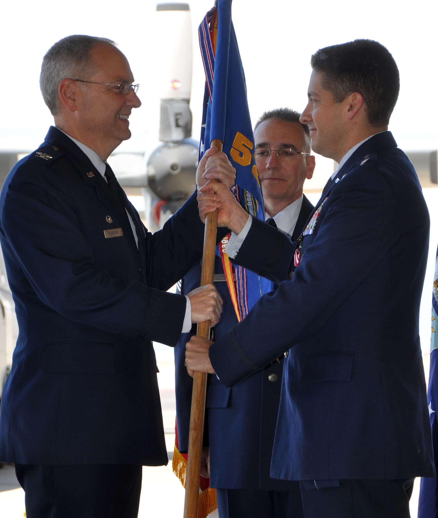 Lt. Col. Carlos Ortiz (right) passes the 52nd Airlift Squadron guidon to Col. David Kasberg, 19th Operations Group commander, during a squadron change of command ceremony May 14 at Peterson Air Force Base, Colo. Colonel Ortiz relinquished his command to incoming commander, Lt. Col. Patrick Schlichenmeyer, in the squadron's first change of command ceremony since its reactivation in 2009. Colonel Schlichenmeyer, who previously held the position of 52nd AS  director of operations, becomes the leader of the squadron, known as the 'Combat Roos,' that has already logged approximately 2,000 combat hours, flown 1,800 sorties, and has transported more than 3.16 million pounds of cargo. The 52nd AS is an active associate organization partnered with the Air Force Reserve's 302nd Airlift Wing. (U.S. Air Force photo/Ann Skarban)