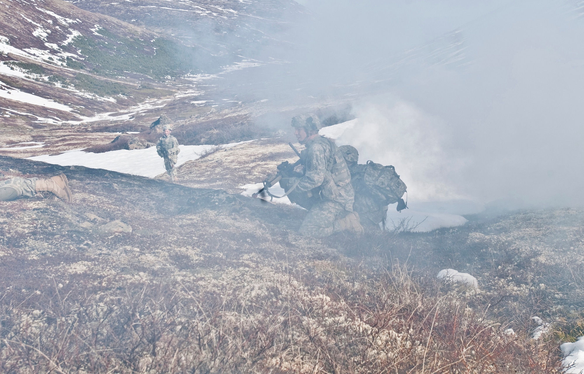 JOINT BASE ELMENDORF-RICHARDSON, Alaska -- Soldiers of the Comanche Company, 1st Battalion, 501st Infantry Regiment (Airborne), make their way through smoke while on an air assault training mission May 12. The Soldiers took part in the air assault training where UH-60 Black Hawk helicopters took them into a section of Alaska's Chugach Range and they were tasked with engaging an opposing force. (U.S. Air Force photo/Senior Airman Christopher Gross)