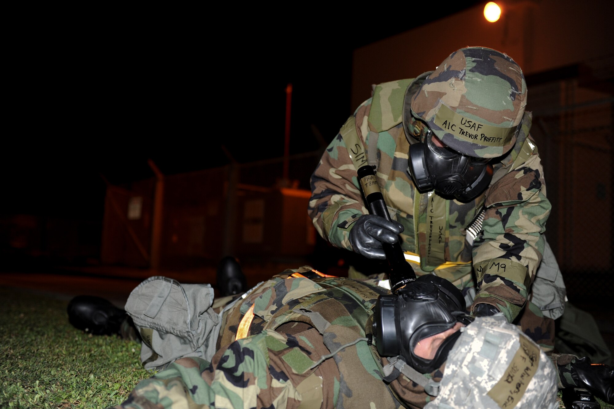 Airman 1st Class Trevor Proffitt checks his fallen Airman for a Mark-1 kit during a scenario, May 18 at Kadena Air Base, Japan.  During a Local Operational Readiness Exercise Airmen will be evaluated on different tasks to maintain skills learned in basic train and throughout their careers. (U.S. Air Force photo by Airman 1st Class Brooke P. Beers)