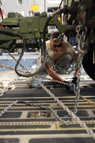 Staff Sgt. Matthew Lumm ties down the back of the HUMVEE during an engine running onload/offload practice on the Joint Base Charleston AFB, flightline May. 18. Sergeant Lumm is an air transportation craftsman with the 437th Aerial Port Squadron and was selected to be a member of the APS Rodeo team. (U.S. Air Force photo/Staff Sgt. Katie Gieratz)(RELEASED)