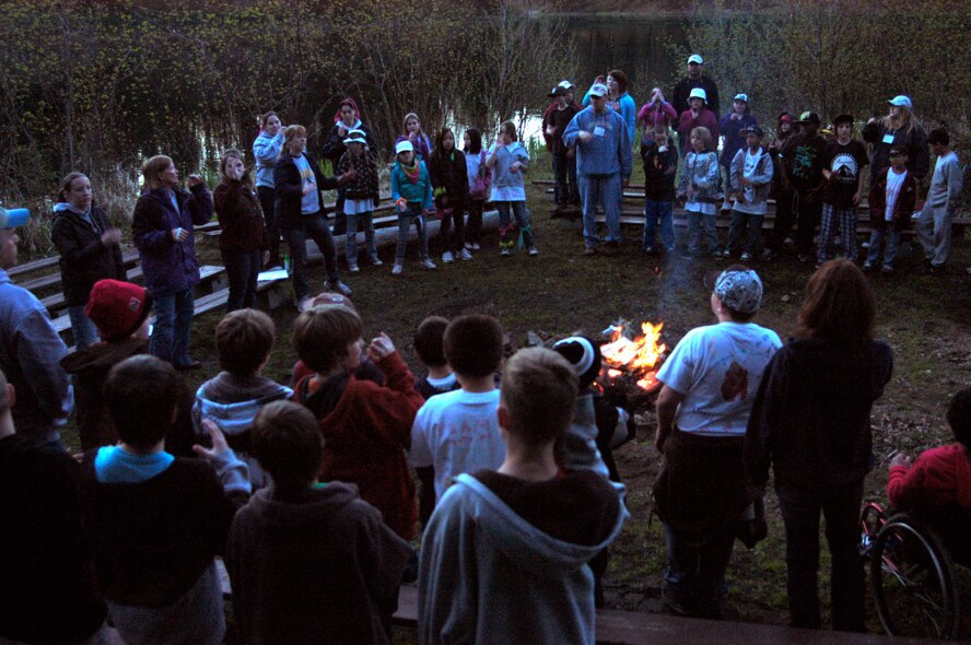 CAMP REED, Wash. -- Fourth graders from Anderson Elementary School sing songs around a fire at Camp Reed May 12, 2011. The fourth grade class made its regular trip there for an overnight campout. The kids enjoyed several hands-on science classes, creative opportunities and other recreational activities. (U.S. Air Force photo/ Staff Sgt. J.G. Buzanowski)