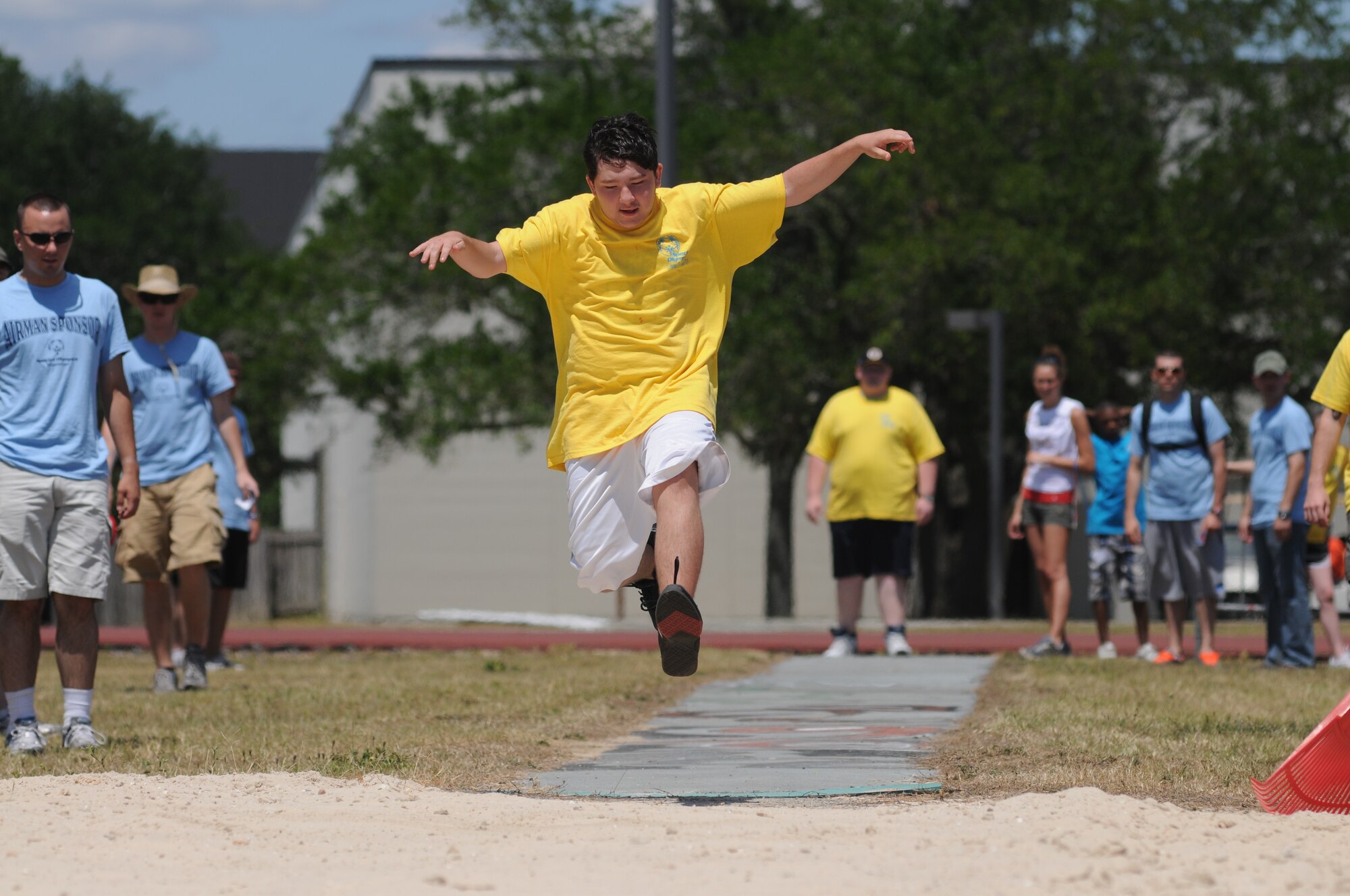 Chandler Pickens, 16, leaps into the air during the running long jump event at Special Olympics, hosted by Keesler Friday and Saturday.  (U.S. Air Force photo by Kemberly Groue)