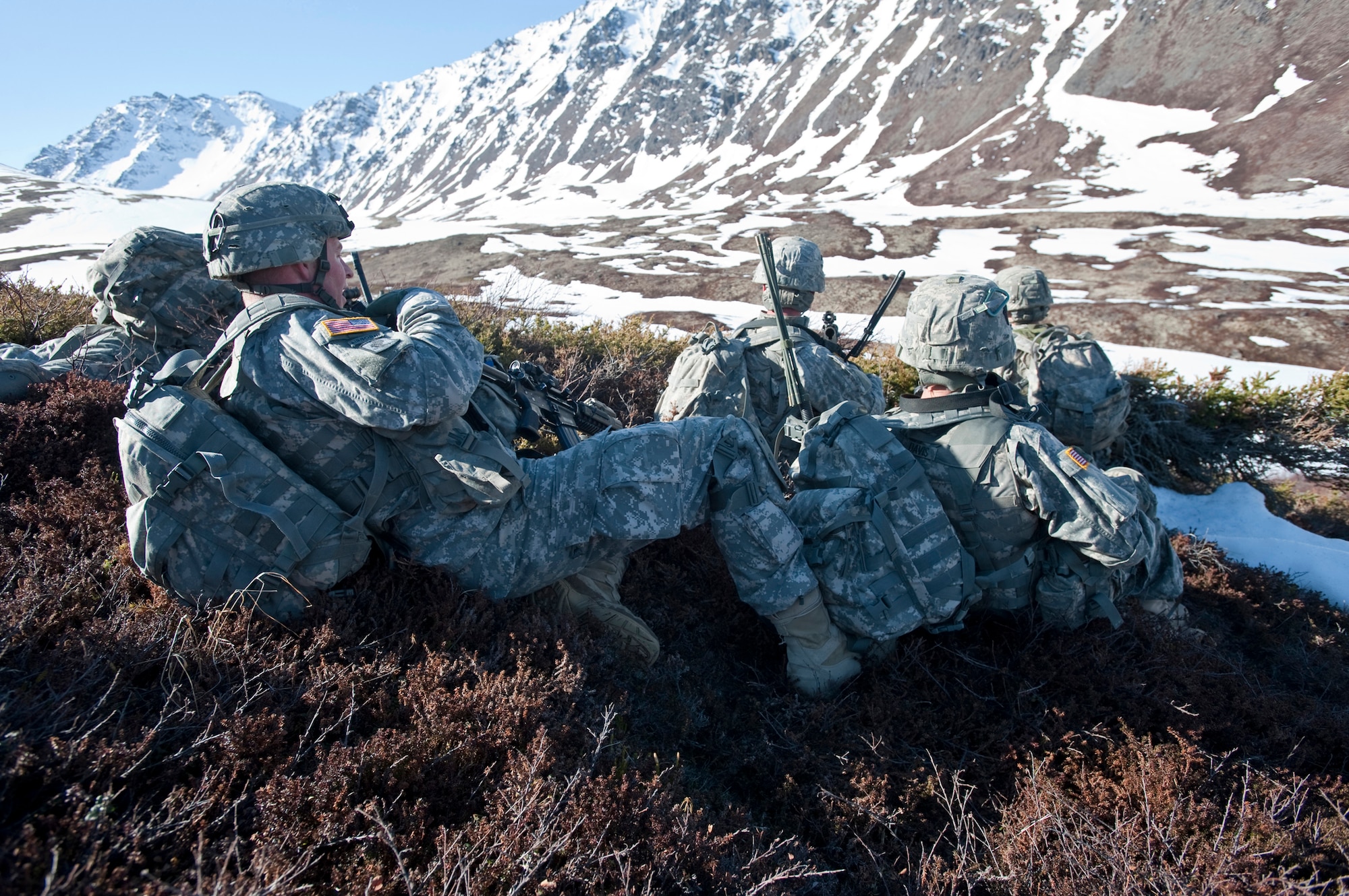 JOINT BASE ELMENDORF-RICHARDSON, Alaska -- Soldiers of Comanche Company, 1st Battalion, 501st Infantry Regiment (Airborne), hide behind some cover before they assault the area below May 12. The Soldiers took part in air assault training where UH-60 Black Hawk helicopters took them into a section of Alaska's Chugach Range and they were tasked with engaging an opposing force. (U.S. Air Force photo/Senior Airman Christopher Gross)