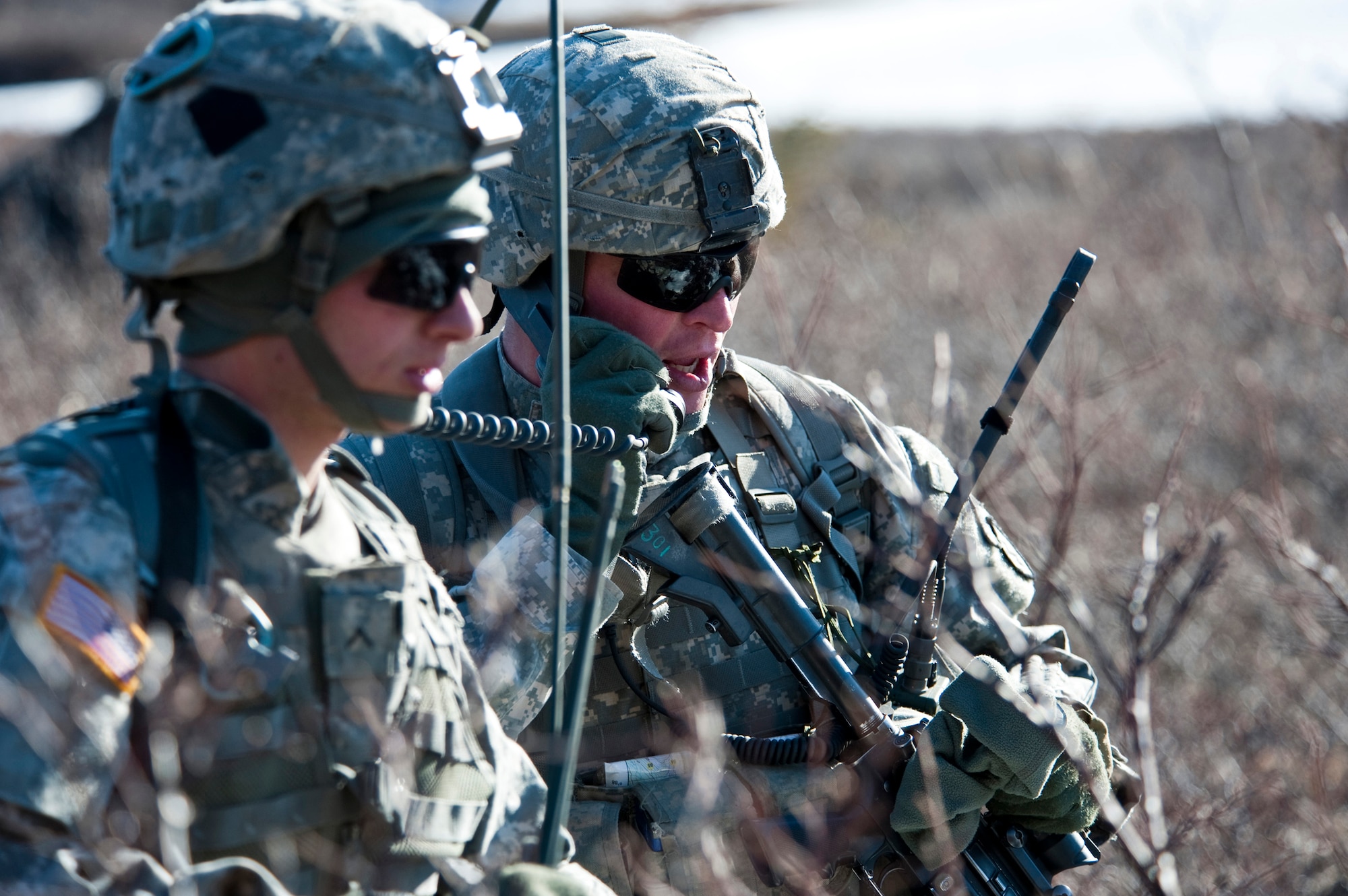 JOINT BASE ELMENDORF-RICHARDSON, Alaska -- Sgt. 1st Class Kyle Silvernale, platoon sergeant, uses the combat net radio from Pvt. Nathan Davis, left, May 12, both are of the  Comanche Company, 1st Battalion, 501st Infantry Regiment (Airborne). The Soldiers took part in air assault training where UH-60 Black Hawk helicopters took them into a section of Alaska's Chugach Range and they were tasked with engaging an opposing force. (U.S. Air Force photo/Senior Airman Christopher Gross)