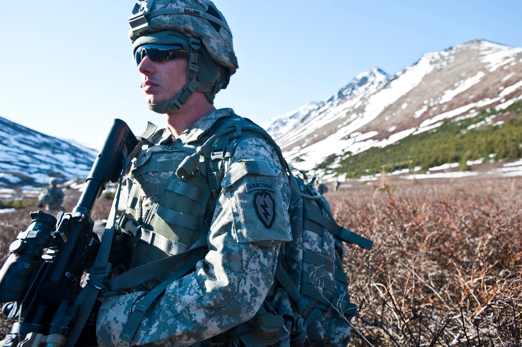 JOINT BASE ELMENDORF-RICHARDSON, Alaska -- Pvt. John Sellers of Comanche Company, 1st Battalion, 501st Infantry Regiment (Airborne), takes a knee while keeping an eye out for any "enemy" that might be in the area May 12. The Soldiers took part in air assault training where UH-60 Black Hawk helicopters took them into a section of Alaska's Chugach Range and they were tasked with engaging an opposing force. (U.S. Air Force photo/Senior Airman Christopher Gross)