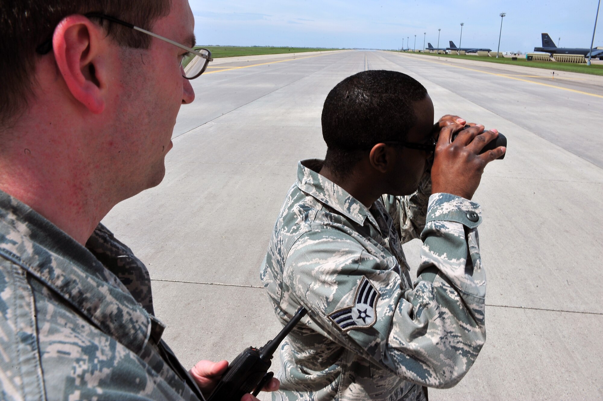 MINOT AIR FORCE BASE, N.D. -- Staff Sgt. Joshua Stillwagon, 5th Operations Support Squadron NCO in charge of airfield management operations, instructs Senior Airman Rondarrius McDonald, 5th OSS airfield operator, on the use of a range finder here May 17. Tools like these are used by airfield management personnel to measure distances among objects and equipment in the flightline. Sergeant Stillwagon recently earned the Air Force Global Strike Command airfield management NCO of the year award for his highly qualified supervisorial skills. (U.S. Air Force Photo/Senior Airman Jesse Lopez)