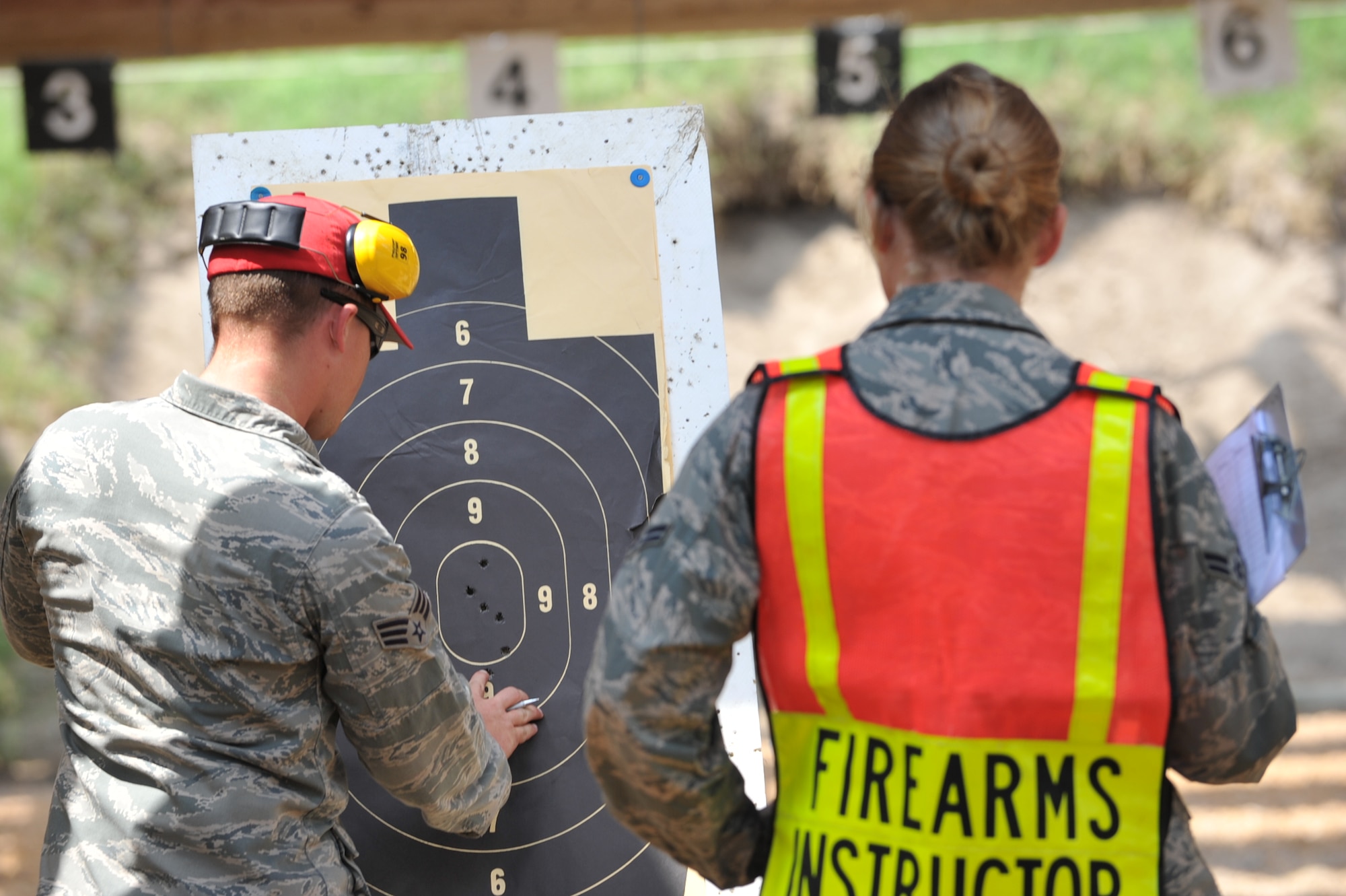 Senior Airman Patrick McCoy, 633d Security Forces Squadron combat arms training and maintenance instructor, and Airman 1st Class Sandra Flanery, 633d Security Forces Squadron member, add up the score on a target during the 633d Security Forces shooting competition at Langley Air Force Base, Va., May 16, 2011. The competition was held as part of National Police Week to honor military and civilian defenders.(U.S. Air Force photo by Airman 1st Class Camilla Griffin)(RELEASED)