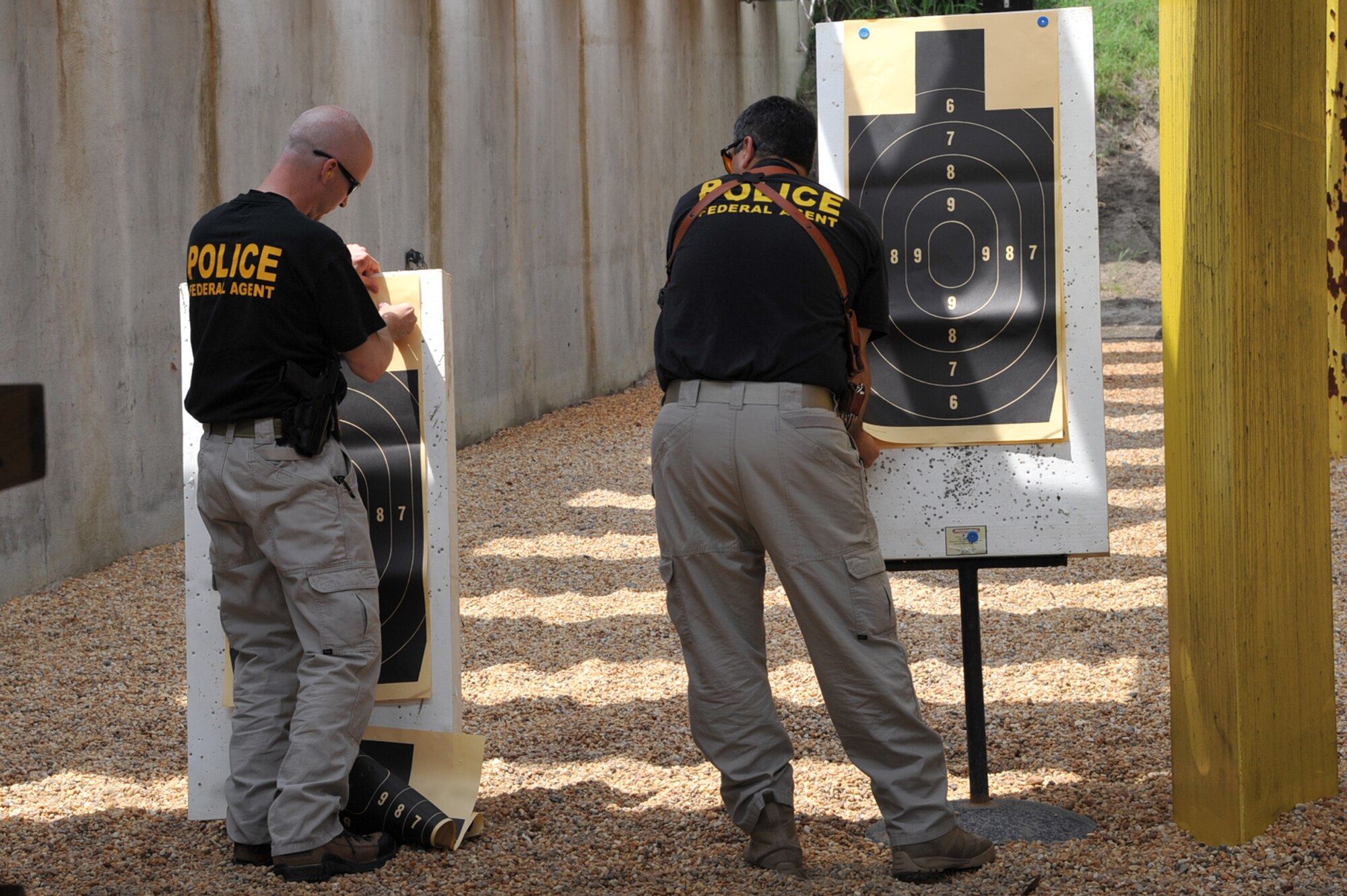 Special Agents Dave Flanagan, Air Force Office of Special Investigations 3rd Field Investigation Squadron, and Michael Hassan, Air Force Office of Special Investigations 2nd Field Investigations Region, change their targets during the 633d Security Forces shooting competition at Langley Air Force Base, Va., May 16, 2011. Participants from the Hampton police department, Hampton park rangers, security forces, Newport News police department and the Air Force Office of Special Investigations competed in the event held as part of National Police Week.(U.S. Air Force photo by Airman 1st Class Camilla Griffin)(RELEASED)