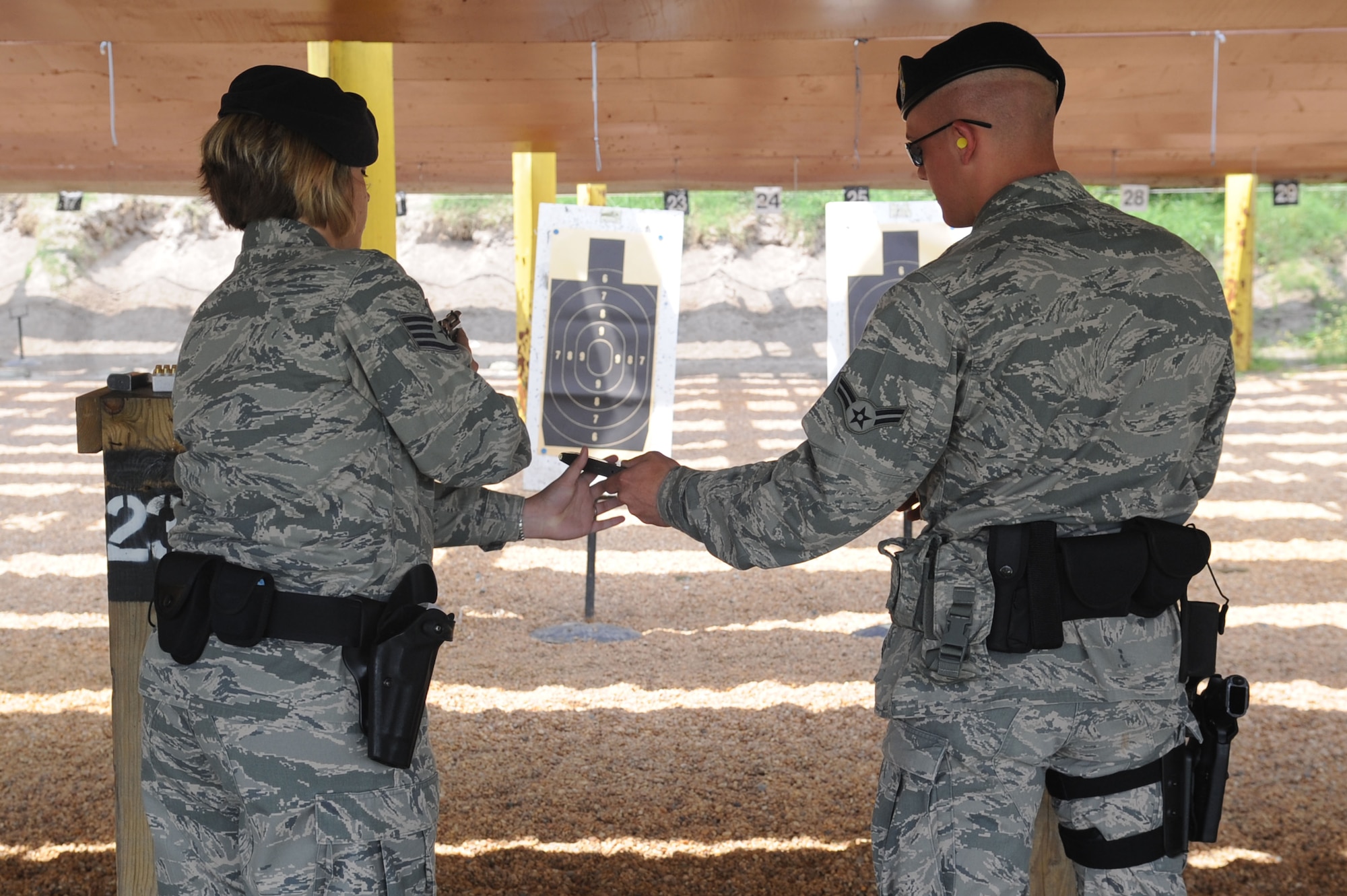 Airman 1st Class David Shreve, 633d Security Forces Squadron member, passes Staff Sgt. Christy Daugherty, 633 SFS emergency controller, a loaded clip during the 633d Security Forces shooting competition at Langley Air Force Base, Va., May 16, 2011. The shooting competition was open to any law enforcement agency within Hampton Roads and took place as part of National Police Week. (U.S. Air Force photo by Airman 1st Class Racheal Watson)(RELEASED)