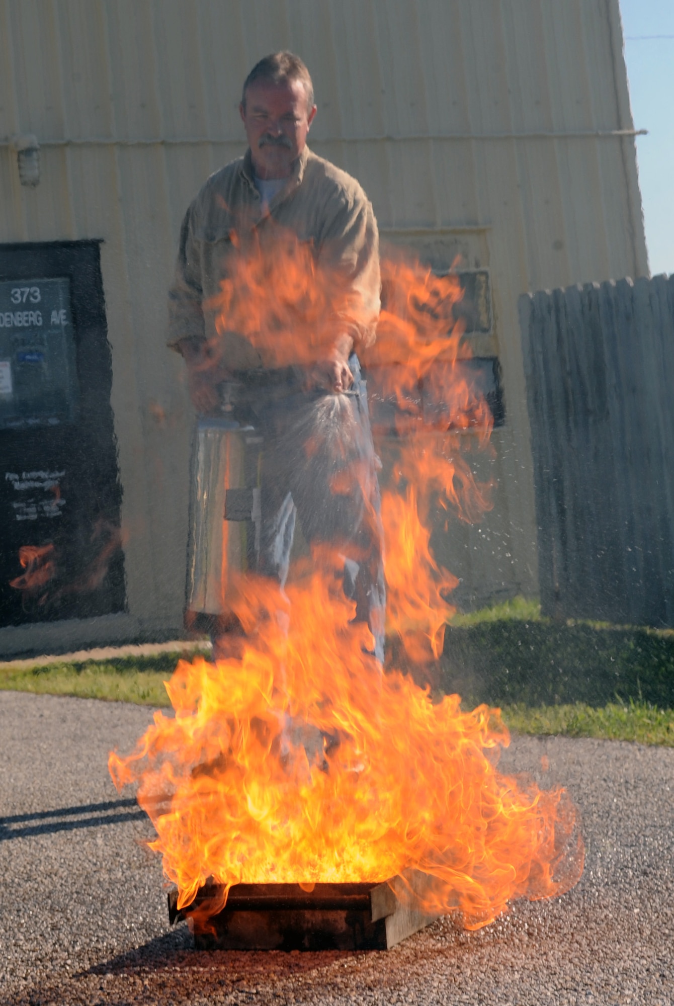WHITEMAN AIR FORCE BASE, Mo. --  Mike Simons, 509th Civil Engineer Squadron extinguisher maintenance technician, demonstrates how water will ignite a grease fire at Whiteman Air Force Base, Mo., May 16. Team Whiteman should plan and use common sense before the first piece of charcoal is lit or the first hamburger hits the grill. (U. S. Air Force photo by Senior Airman Alexandra M. Boutte)