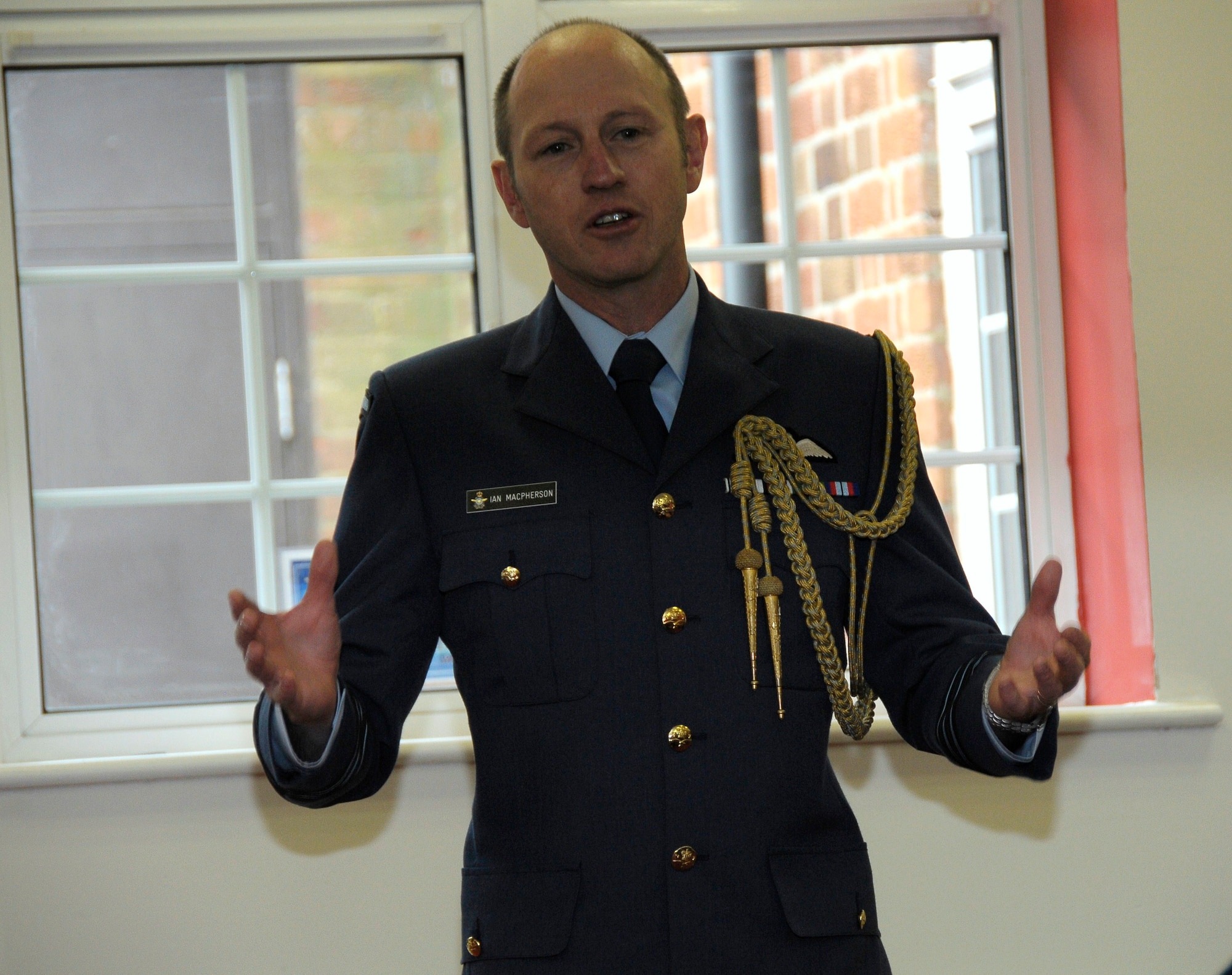 ROYAL AIR FORCE FELTWELL, England -- Guest speaker Wing Commander Ian MacPherson, Air Advisor-Defence Staff, Royal New Zealand Air Force, London, speaks during the dedication ceremony of the newly renamed Ward Community Activity Center on May 14, 2011. The building was named in honor of Sgt. James A. Ward, the first New Zealander awarded the Victoria Cross; the British equivalent of the Medal of Honor. Sergeant Ward was stationed at RAF Feltwell with the Royal New Zealand Air Force No. 75 Squadron during World War II. He was awarded the medal for his heroic actions on July 7, 1941, when his Wellington bomber caught fire from an enemy attack. (U.S. Air Force photo/Staff Sgt. Connor Estes)